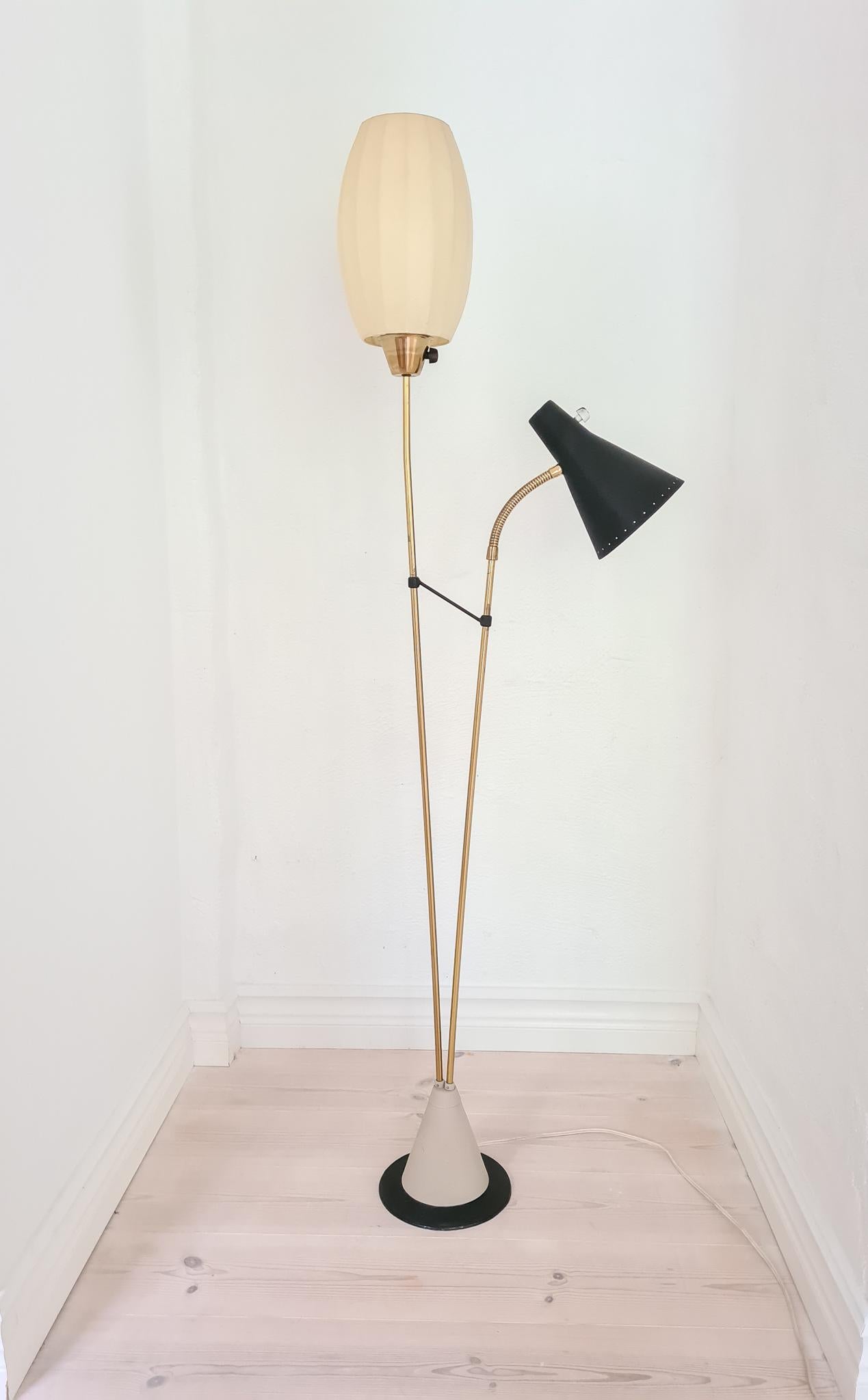 Genuinely nice Swedish floor lamp made in Sweden for Ateljé Lyktan and attributed to Hans Bergström. The base is made with iron casting and continues with brass. The two-light sources itself are the original shades made from plastic and a