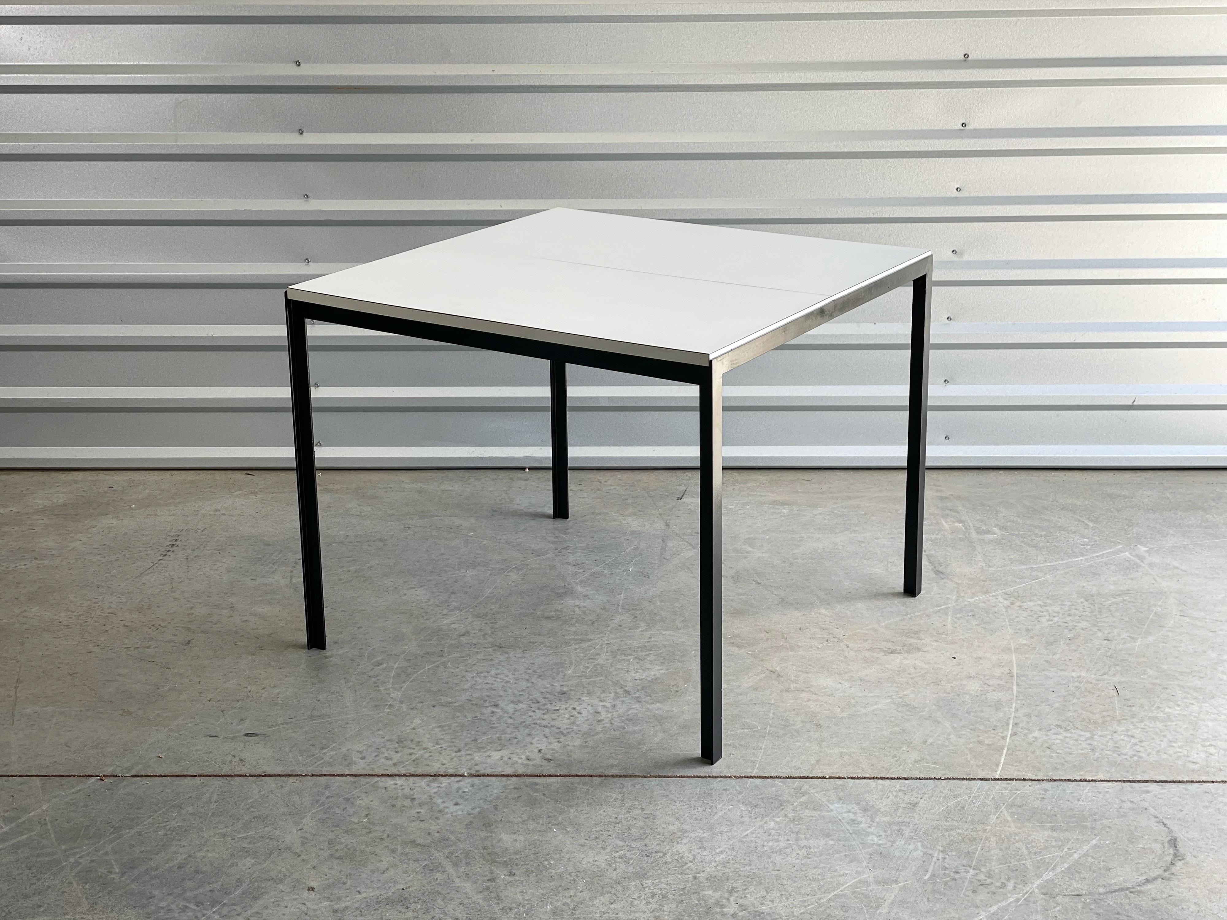 Seldom seen T Angle dining table with butterfly leaf by Florence Knoll, circa early 1960's. Black angle iron frame with a white formica top. Seats for with the leaf stowed below and up to six with the leaf extended; perfect for a small space. Very