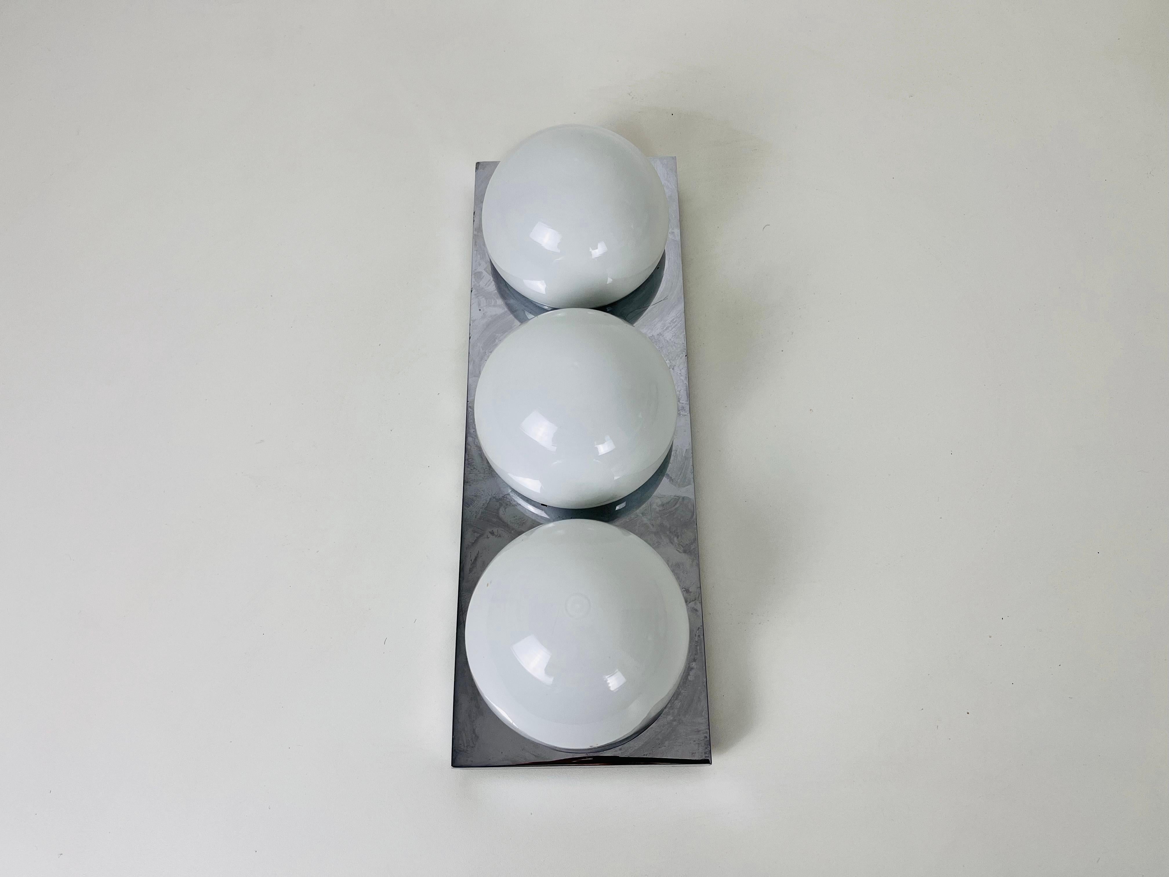 A Mid-Century Modern flush mount or wall lamp by Glashütte Limburg made in the 1960s in Germany. It is fascinating with its beautiful shape and opaline glasses. The fixture has a very nice Minimalist design.

The light requires one E27 (US E26)