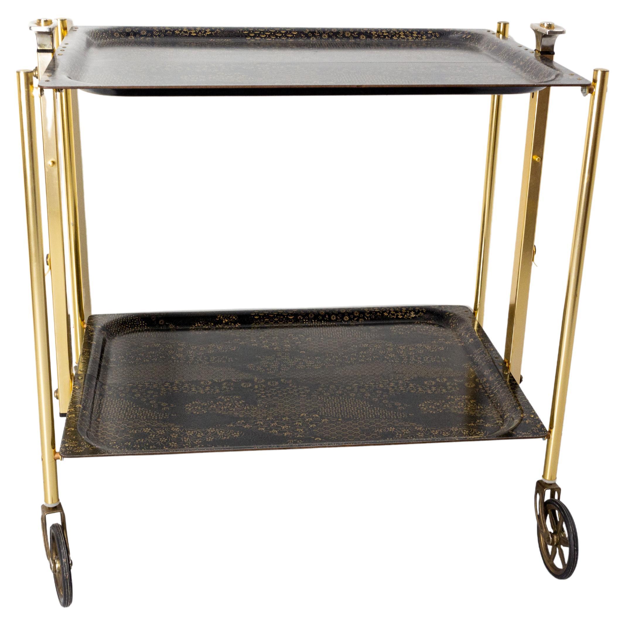 Black and golden serving trolley folding bar cart drinks midcentury, circa 1960s.
This serving trolley can also be used as a side table.
In very good working order.
Very versatile, practical and light.
Very easy to fold.
Very good vintage
