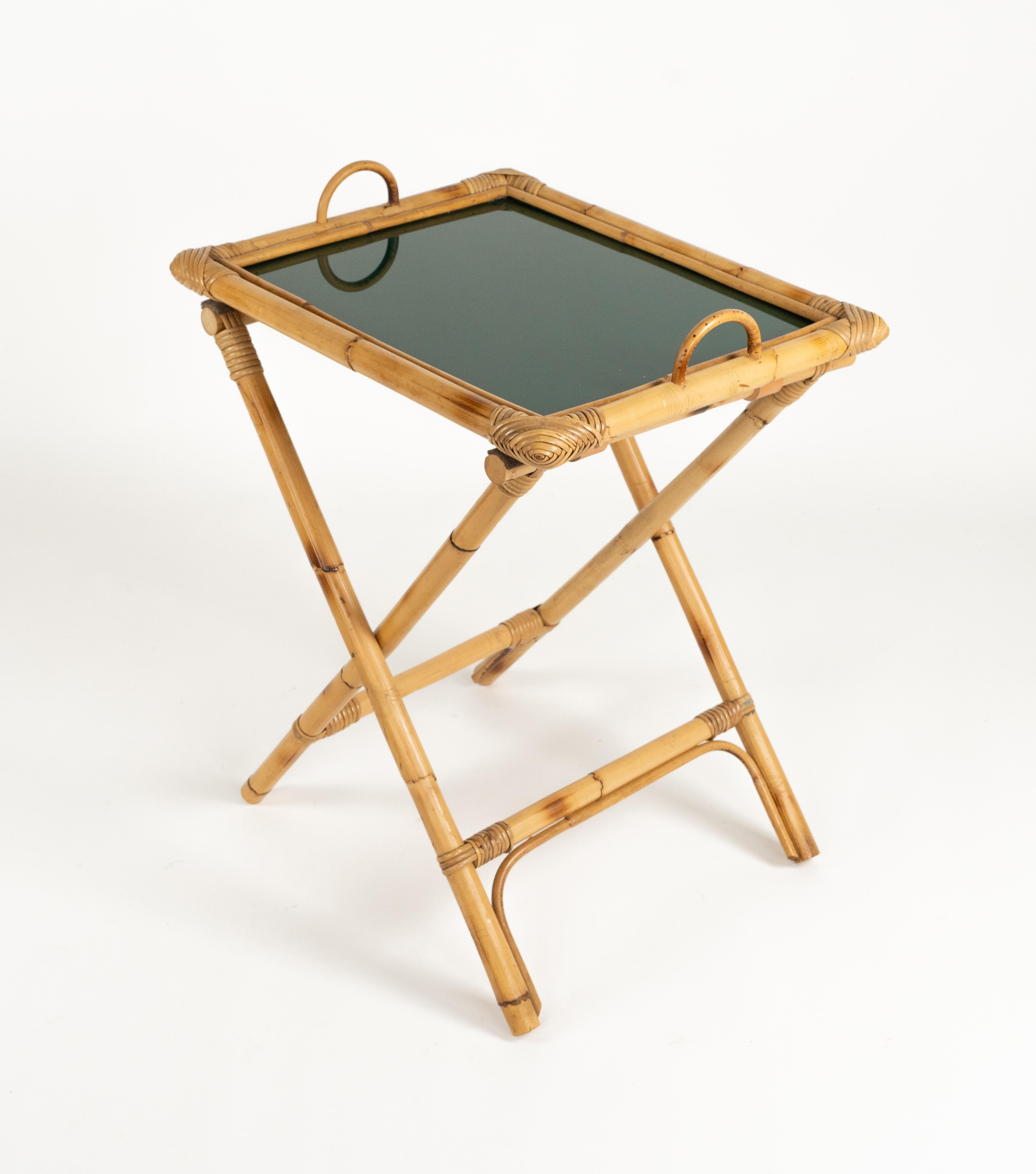 Midcentury beautiful folding table with removible tray in bamboo, rattan, leather and glass.

Made in Italy in the 1970s.

Lovely to be used as bar or cocktail tray table and occasional side or end table.

Lovely to add a midcentury taste as drinks