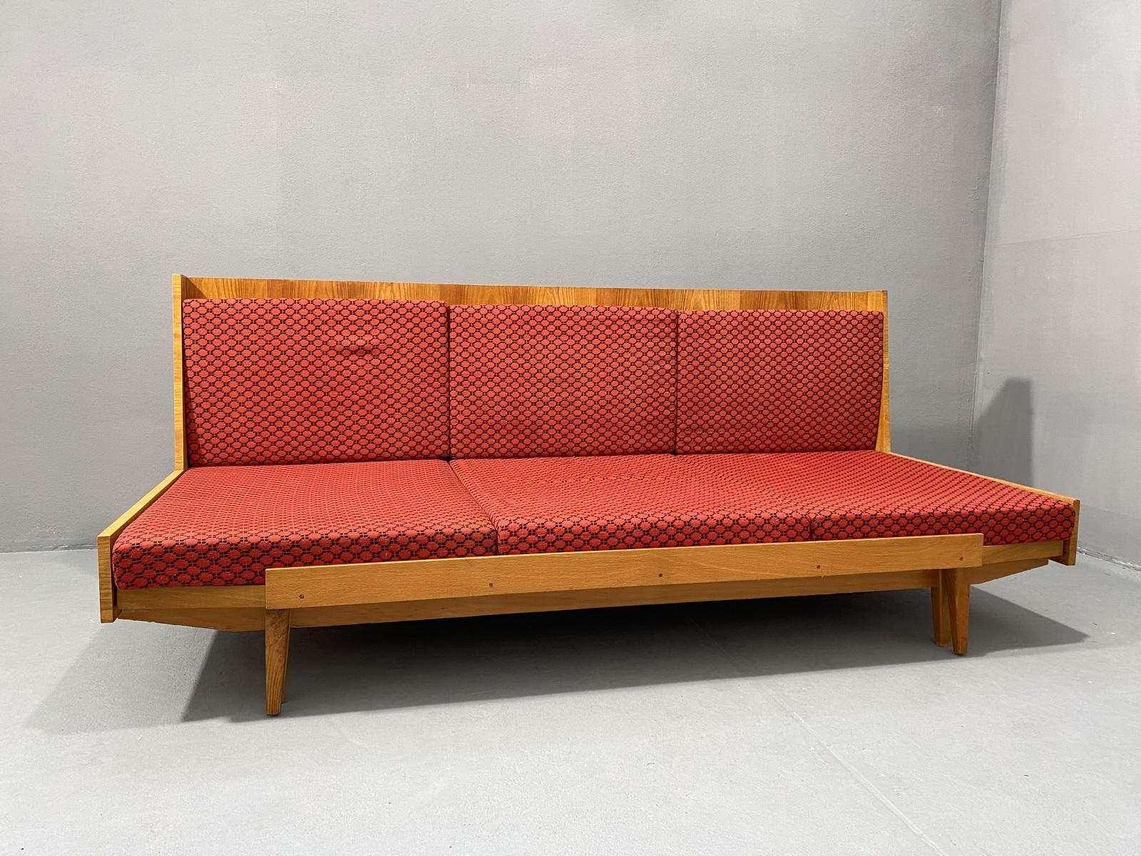 This mid century sofabed was made in the former Czechoslovakia in the 1970s. The sofa has a beechwood and playwood structure and original upholstery. These sofas are currently very popular, both due to their attractive appearance and their