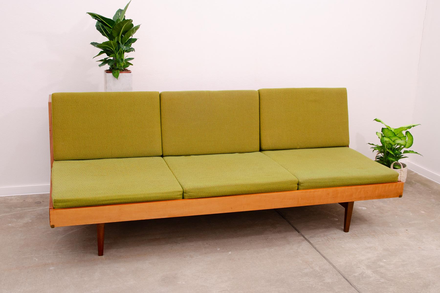 Midcentury sofa bed, made by Jitona company in the former Czechoslovakia in the 1970s. The sofa is made of walnut wood and has an original upholstery. The sofa is in a well-preserved and good condition, however, it bears reasonable signs of age and