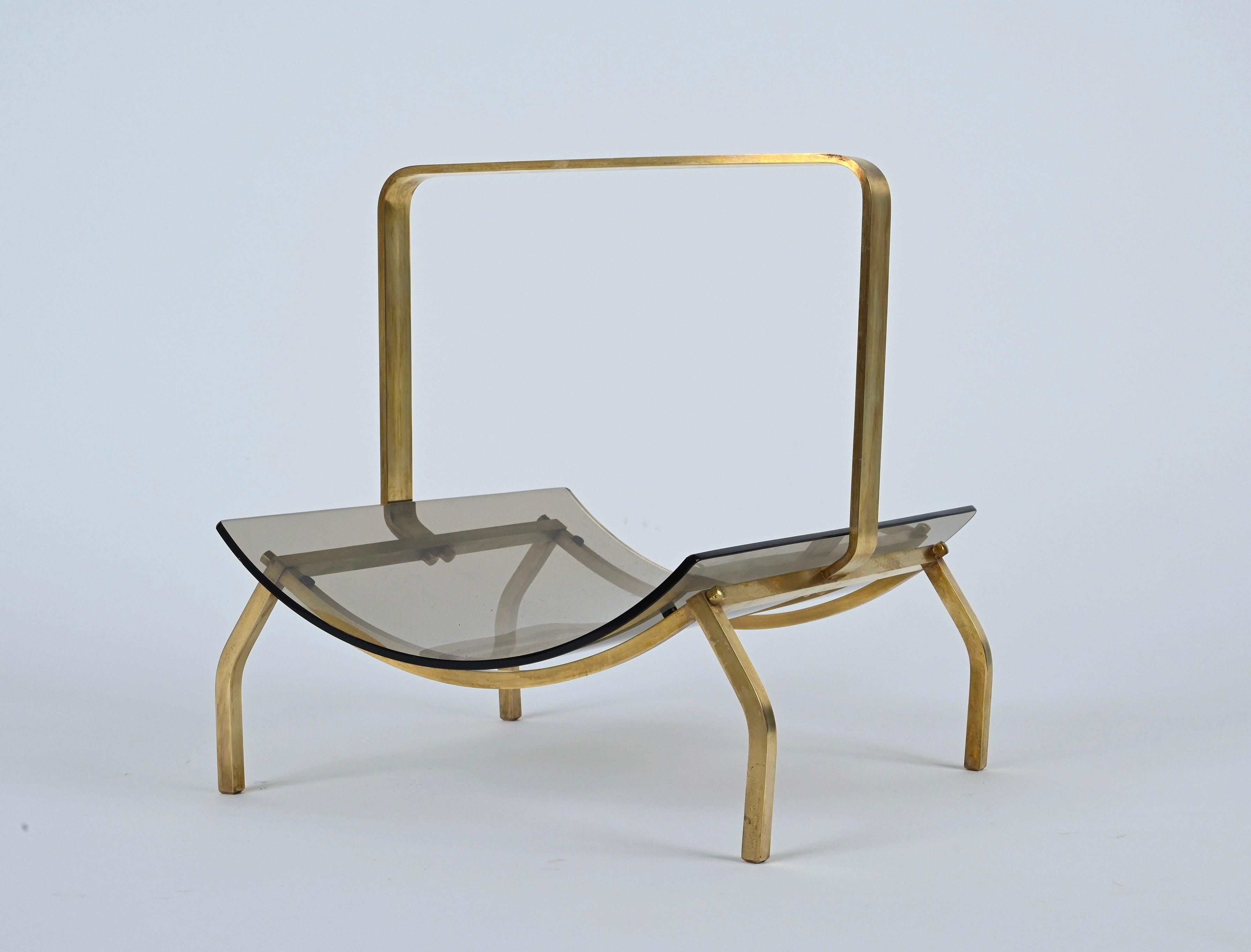 Beautiful Mid-Century Modern newspaper and magazine rack designed and manufactured by Fontana Arte in the 1960s. It's made of solid brushed brass and thick smoked glass.

Dimensions:
H 39.5 cm / 15.5 in.
W 40 cm / 15.7 in.
D 38 cm / 114,96 in.