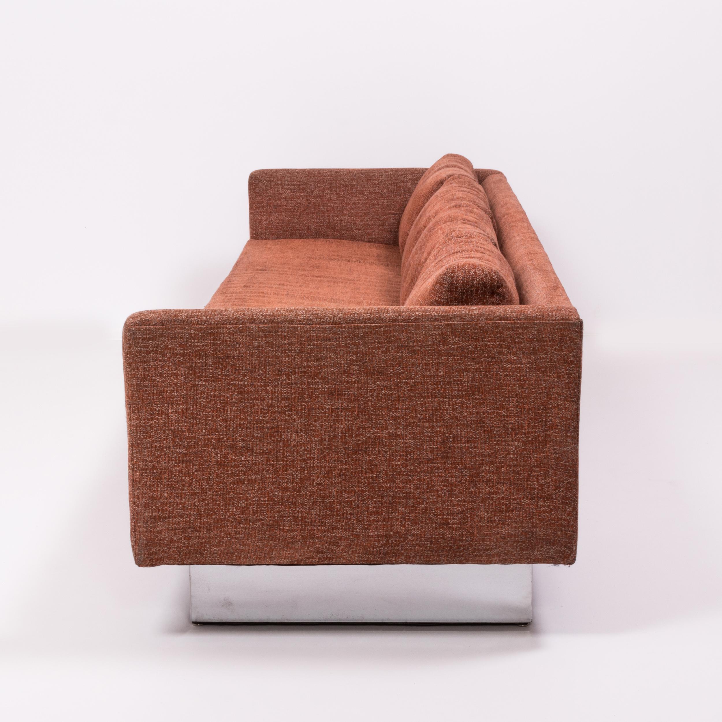 A Minimalist 1960s design, this tuxedo four-seat sofa is upholstered in the original orange tweed fabric.

Designed by Milo Baughman, the sofa features a slim, angular Silhouette with a set back base with a chrome finish, giving the effect of the