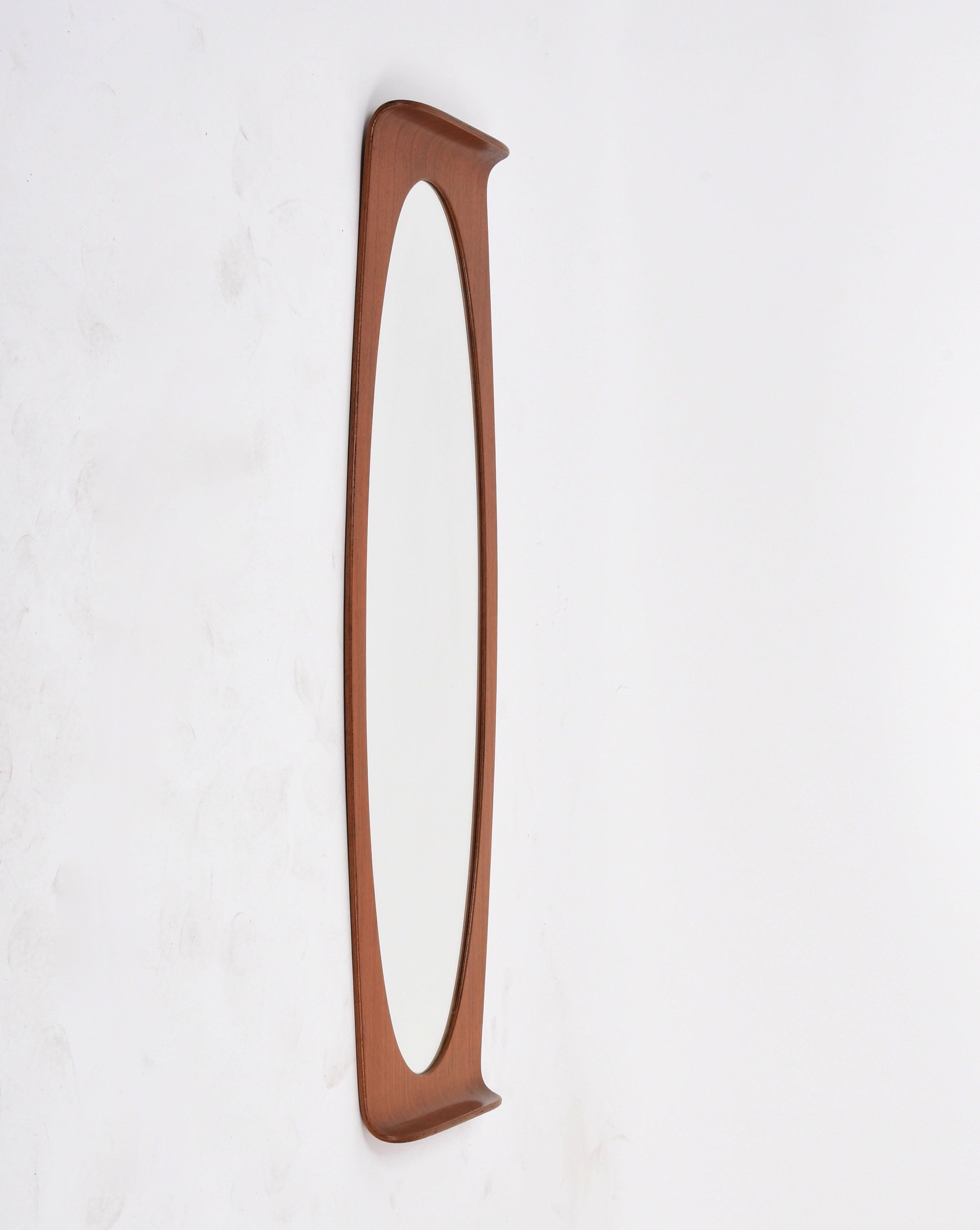 Amazing mid-century curved wood elliptical wall mirror. This fantastic piece was designed by Franco Campo and Carlo Graffi in Italy during the 1960s.

This great item is wonderful because of its lines, like the elliptic mirror while the wooden