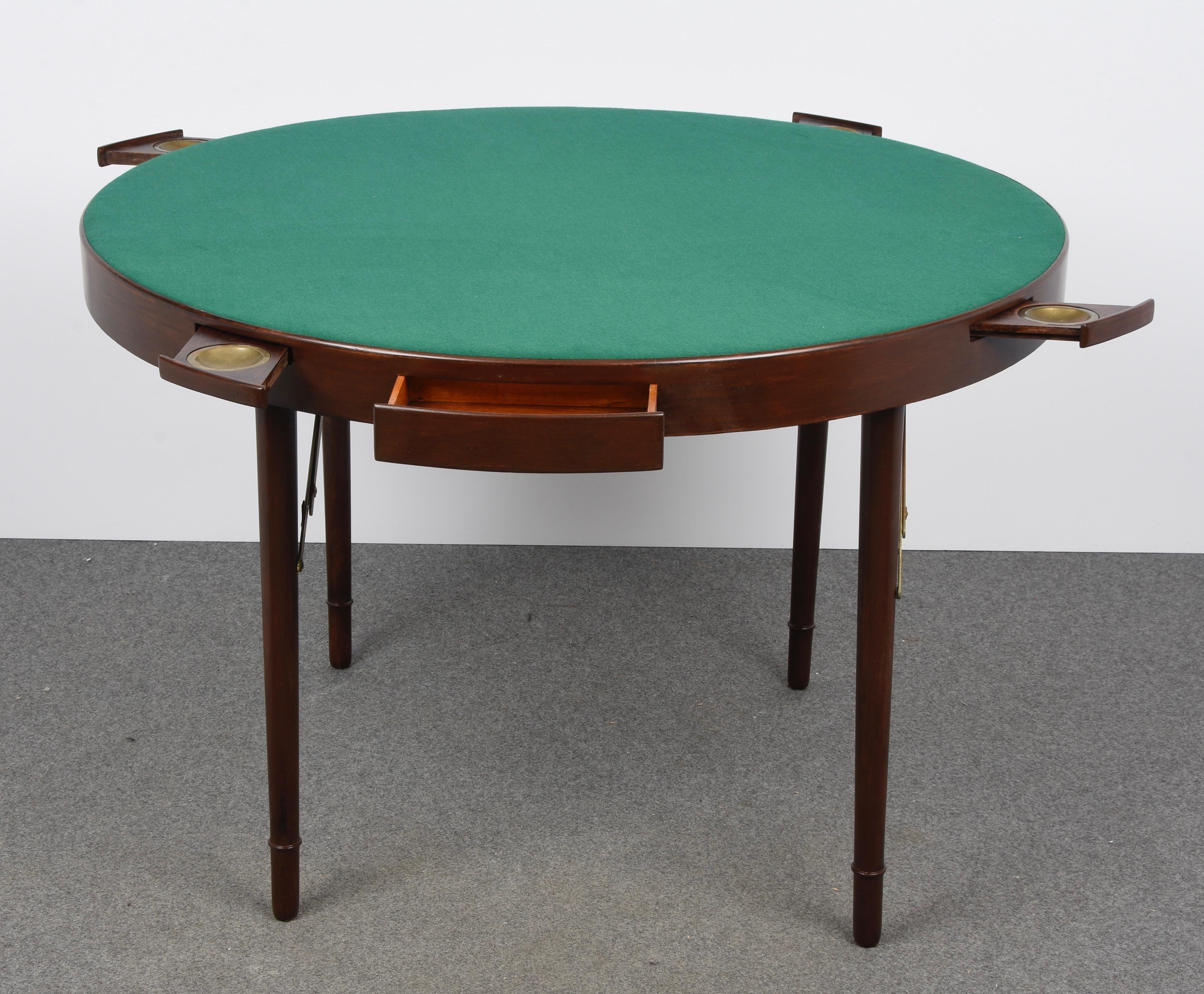 Superb round game table with wooden structure, two drawers and four removable ashtrays in solid brass. This fantastic item was designed by the Zari Brothers in Milano, Italy, during the 1950s.

This piece is unique as it is foldable, it has two
