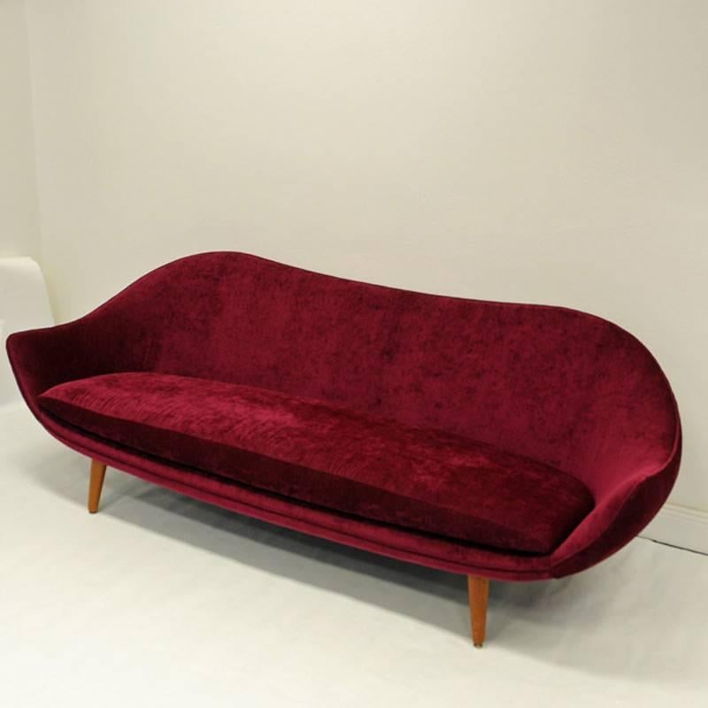 This is a one of a kind Kayser sofa model 860 in beautiful new soft plush upholstery called Nerotex Eros color 11. Lipstick. Teak legs and stom. Small brass details on the legs. Norwegian produced rare sofa of good quality. Special sculptural shaped