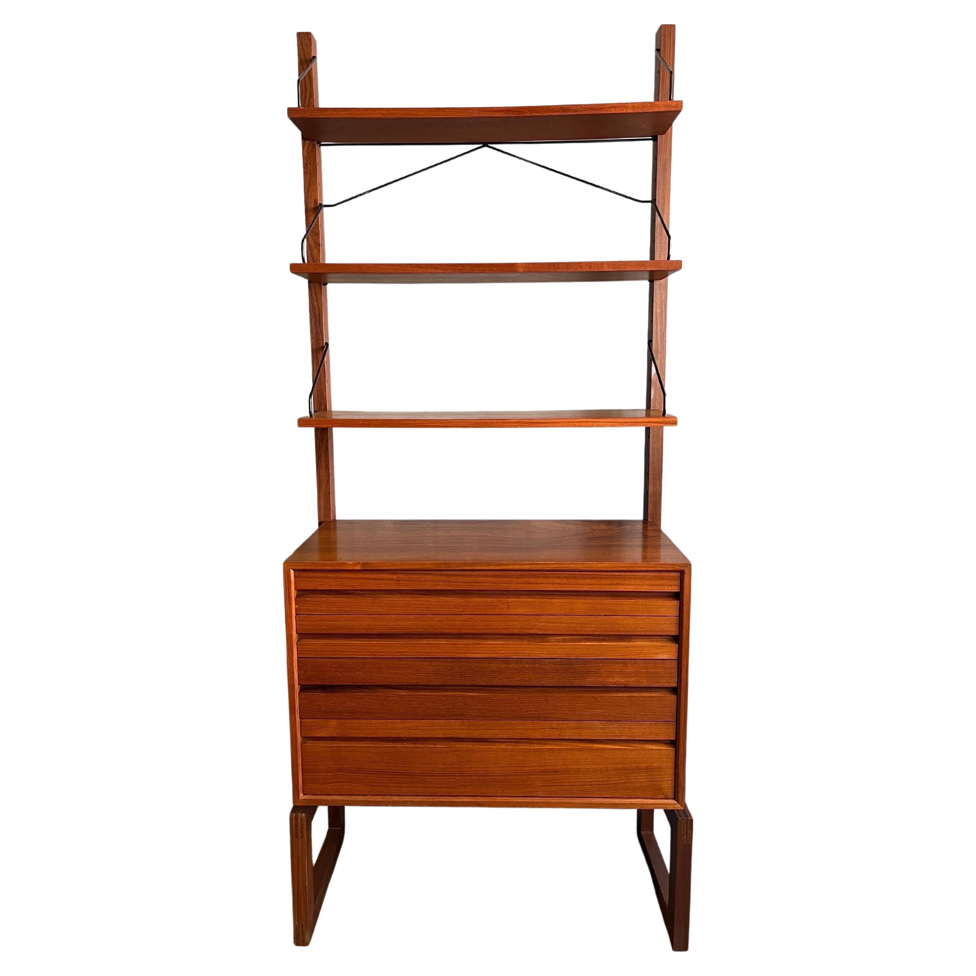 For your consideration is this a lovely one bay while unit in teak wood by Poul Cadovius. Featuring three shelves that are (2) 8 inches deep and 9 inches deep. The unit itself is 33 inches wide and the rails are 77.5 inches high. 4 drawer case piece