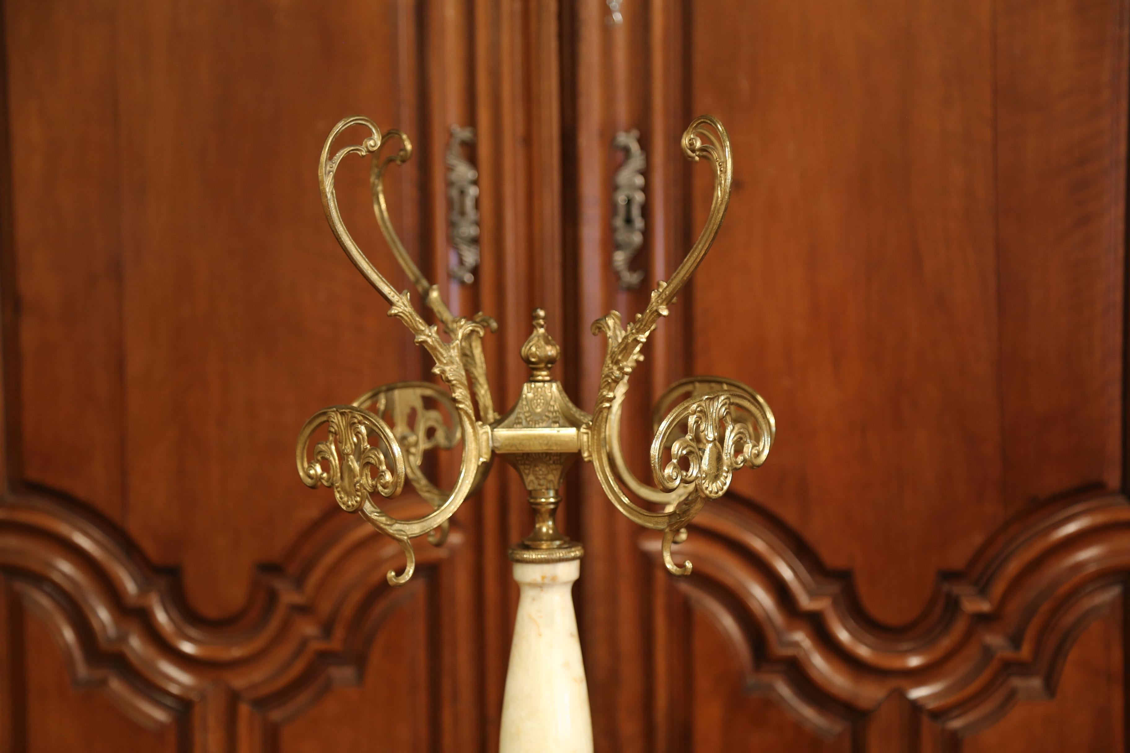 Add a old French touch to your home with this vintage free standing coat rack and hat rack; perfect to hold your clothing and adorn your entryway, master bathroom or close, the brass and onyx stand was created in France, circa 1920. The piece sits