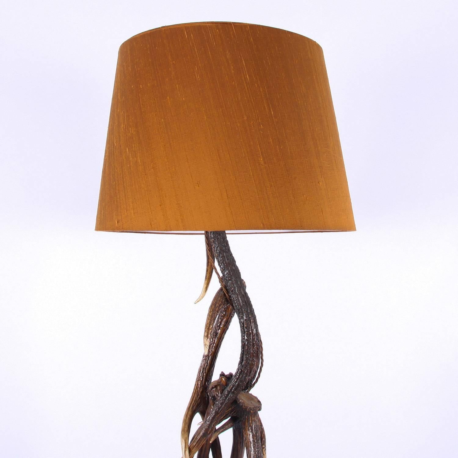 A stylish antler floor lamp, made from several intertwined antlers.

Pictured with a handmade, bespoke, silk lampshade in burnt orange. Rewired and PAT tested.