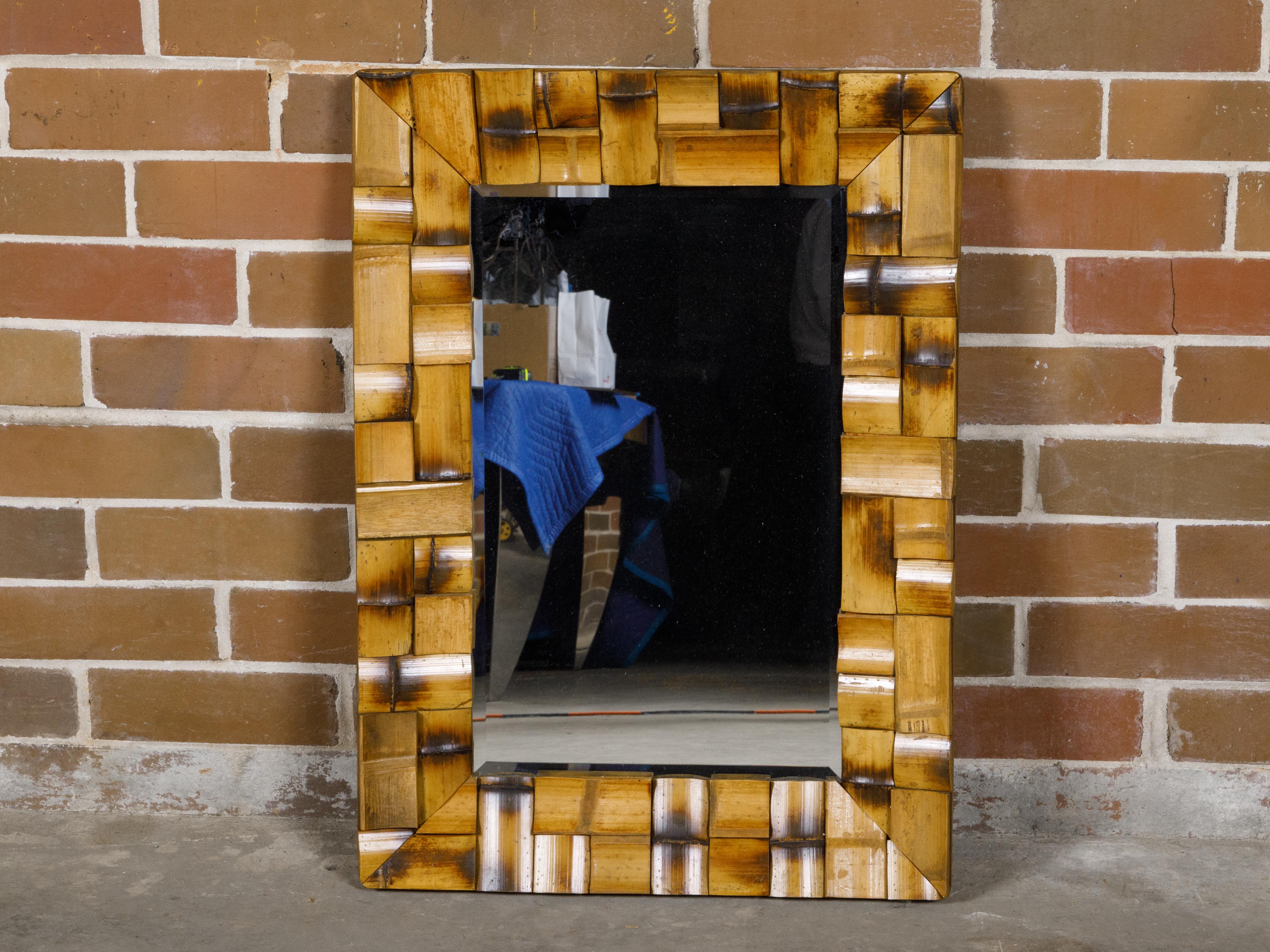 A French Midcentury bamboo mirror with geometric mosaic style arrangement. This French Midcentury wall mirror, featuring bamboo organized in a unique mosaic style arrangement, is a striking example of mid-20th-century design. The bamboo segments are