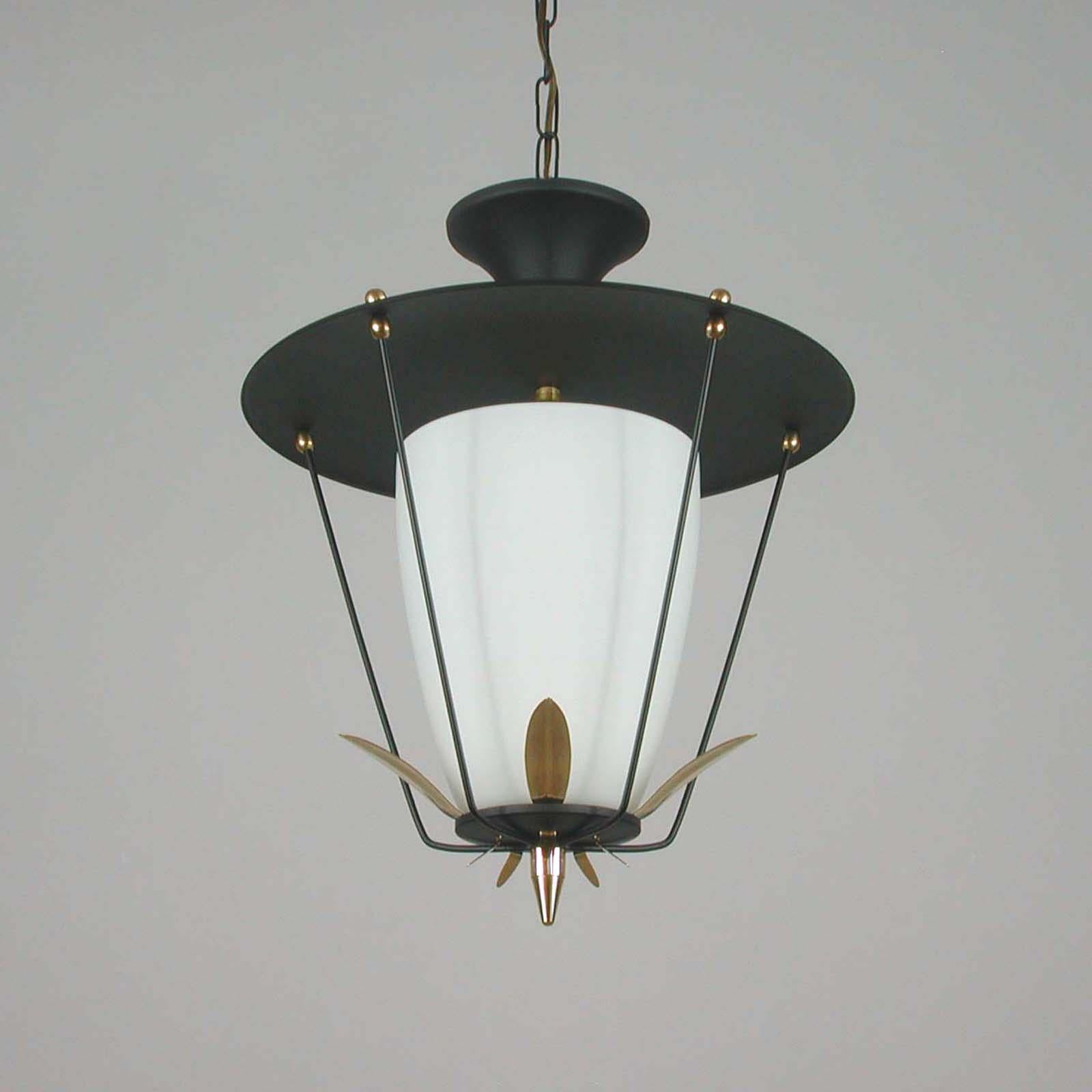 This vintage Maison Arlus / Lunel style lantern / ceiling light was made in France in the 1950s. It is made of black lacquered metal with a white frosted glass diffuser and has got brass details. 

The lantern requires a French B22 bayonet bulb.