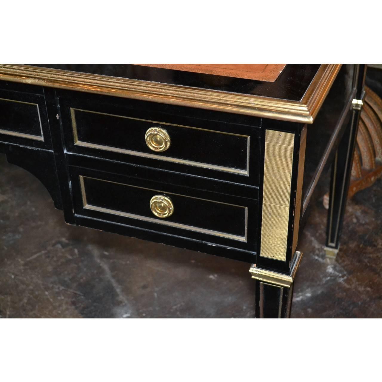 Fabulous midcentury French black lacquered writing desk with a tooled leather top. Fitted with five drawers having brass trim and accented corners. The whole on square tapered legs ending in bronze capped feet,

circa 1940.

 