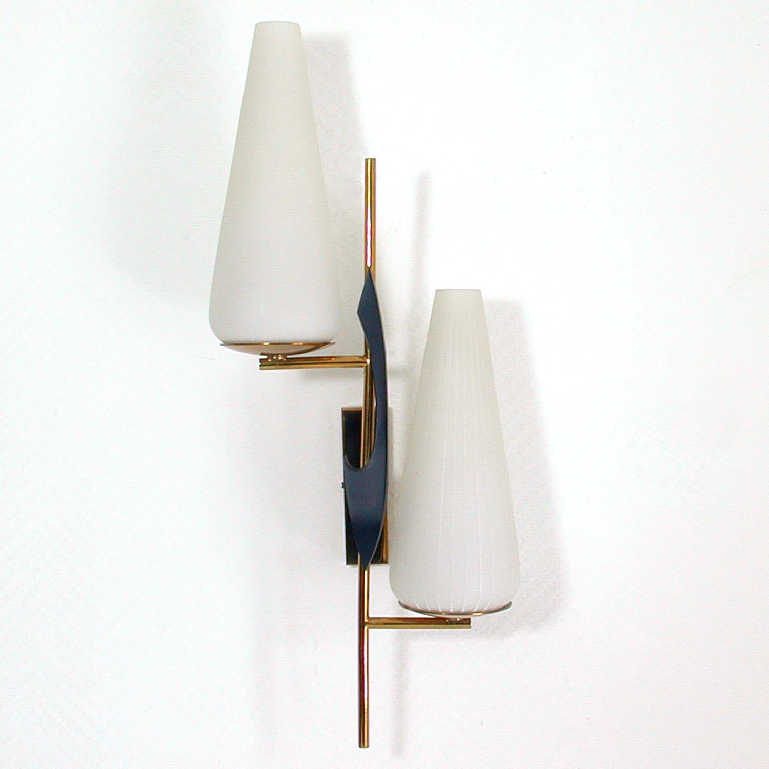 This large awesome French wall light was produced by Maison Arlus in the 1950s. It is made of brass black lacquered iron and has got two opaline glass lamp shades.

The light requires two B22 French bayonet bulbs. It is in very good condition and