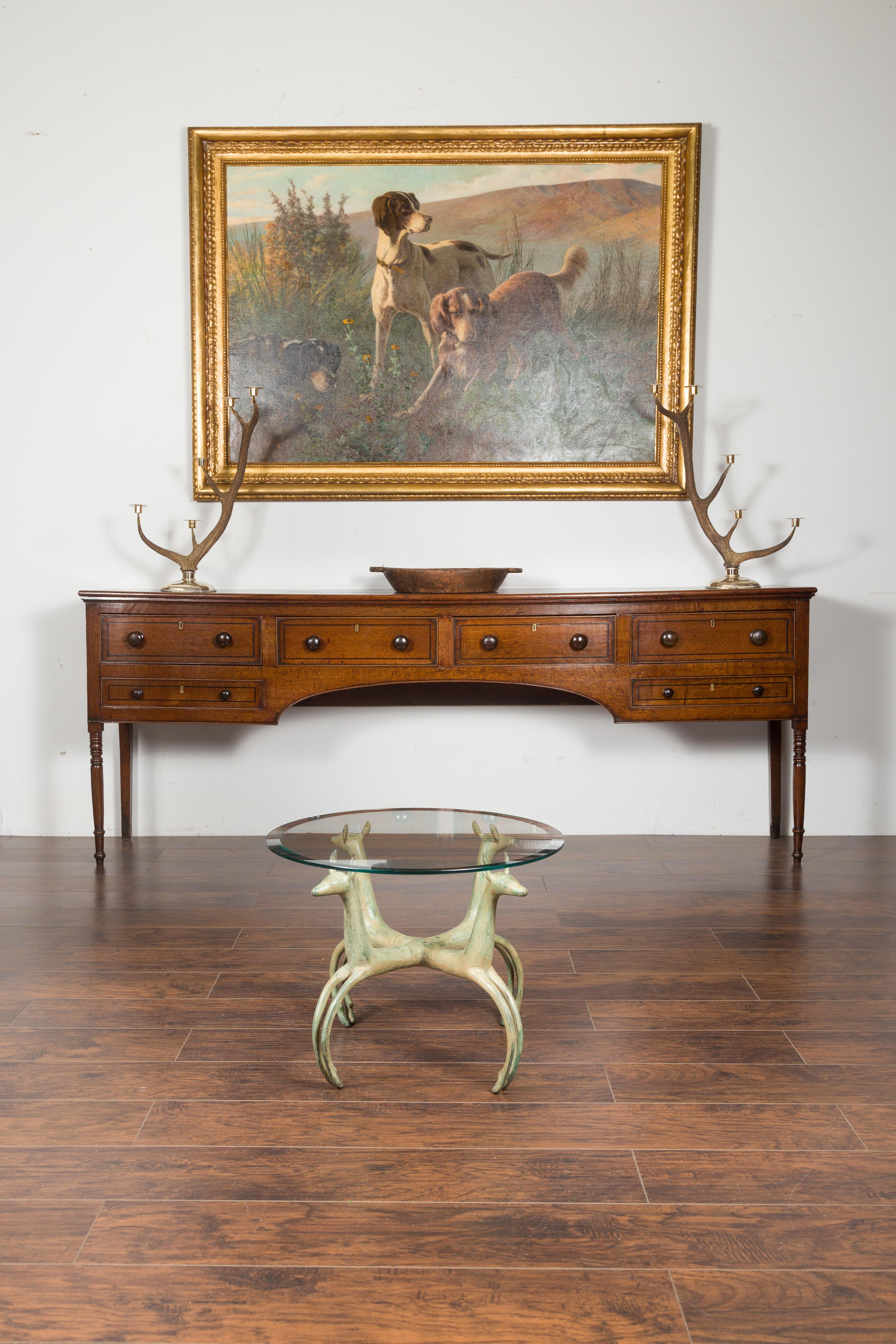 A French vintage bronze low side table from the mid-20th century, with deer motifs and two glass tops. Created in France during the midcentury period, this bronze table features two circular glass tops: the smaller, shown in the first pictures, is