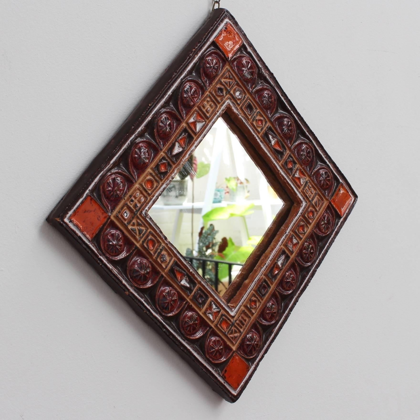 Midcentury French ceramic decorative mirror attributed to Atelier Les Cyclades, Anduze, France, circa 1960s-1970s. A ceramic frame with inset enamel decorative shapes form this colorful square mirror. The glass centre piece is enclosed by