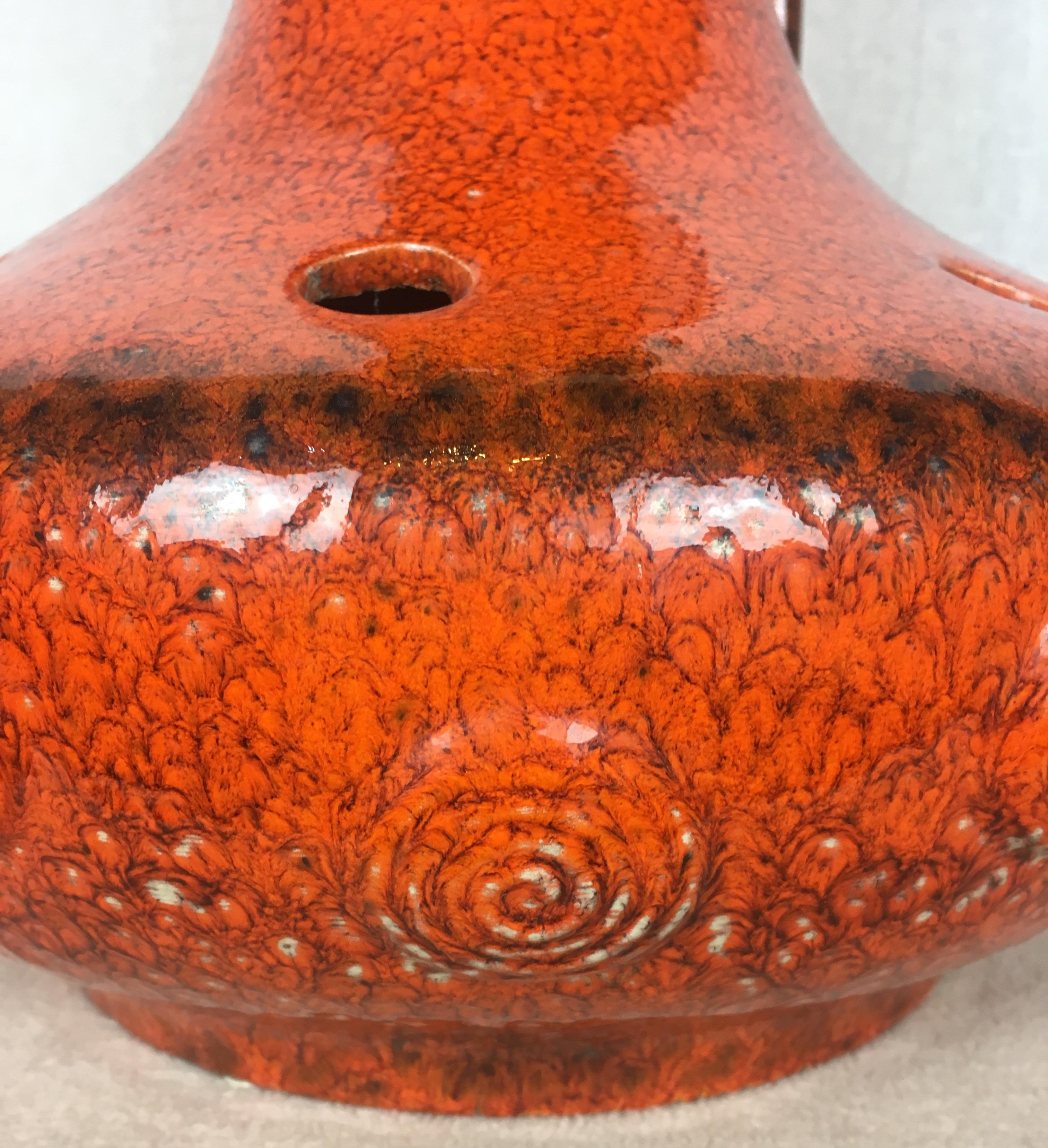 A large and very decorative French mid-century table lamp in a stunning glazed burnt orange ceramic with brown hues. Hand-crafted ceramic piece that originates from Vallauris, France. 
Numbered. 

Very attractive details and a unique, sophisticated
