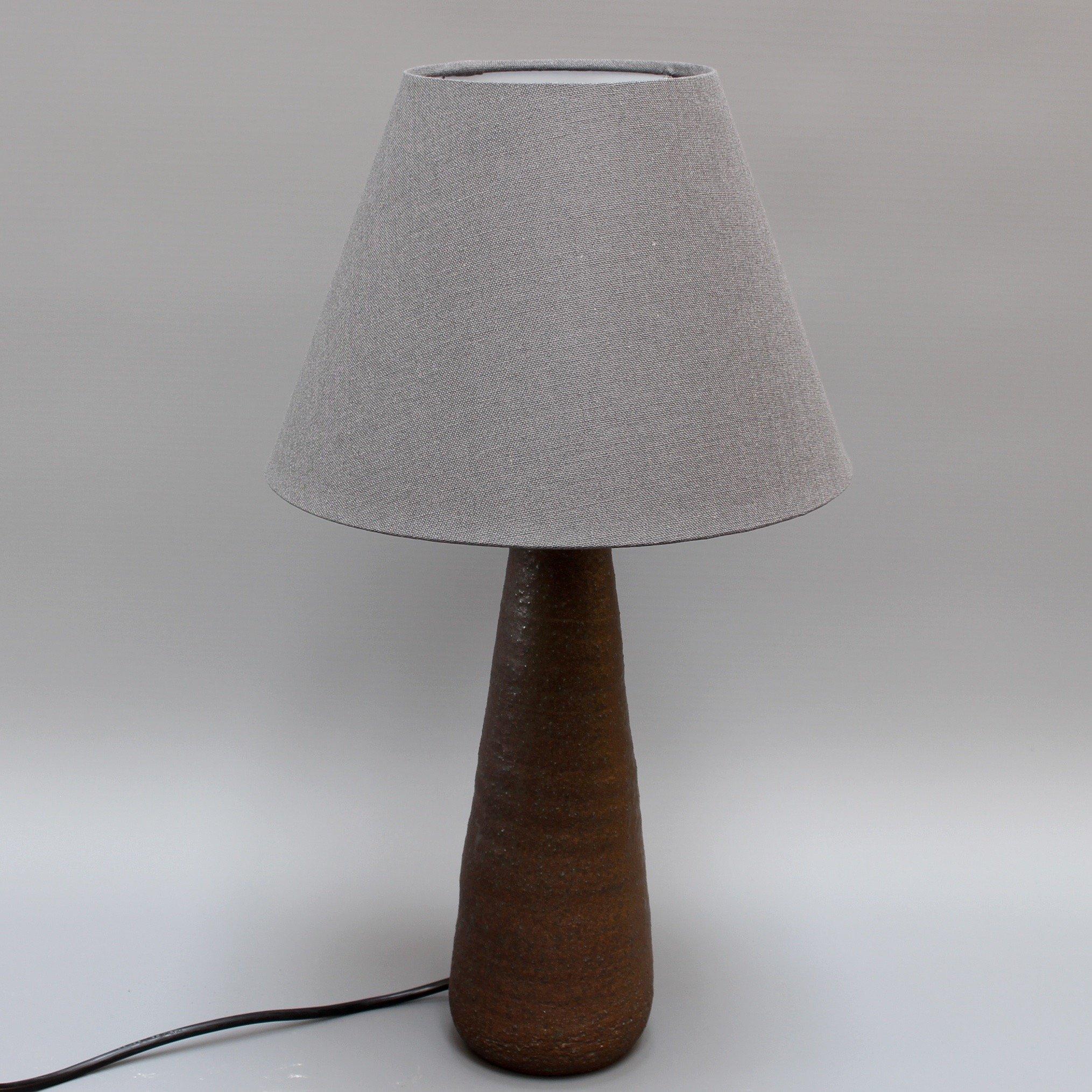Französische Keramik-Tischlampe aus der Mitte des Jahrhunderts von Jean Rivier (um 1960). Eine konisch geformte Lampe aus Steingut mit einer subtilen geschmolzenen grünen Glasur über der braunen matten Oberfläche. Der Ton wurde in Windungen