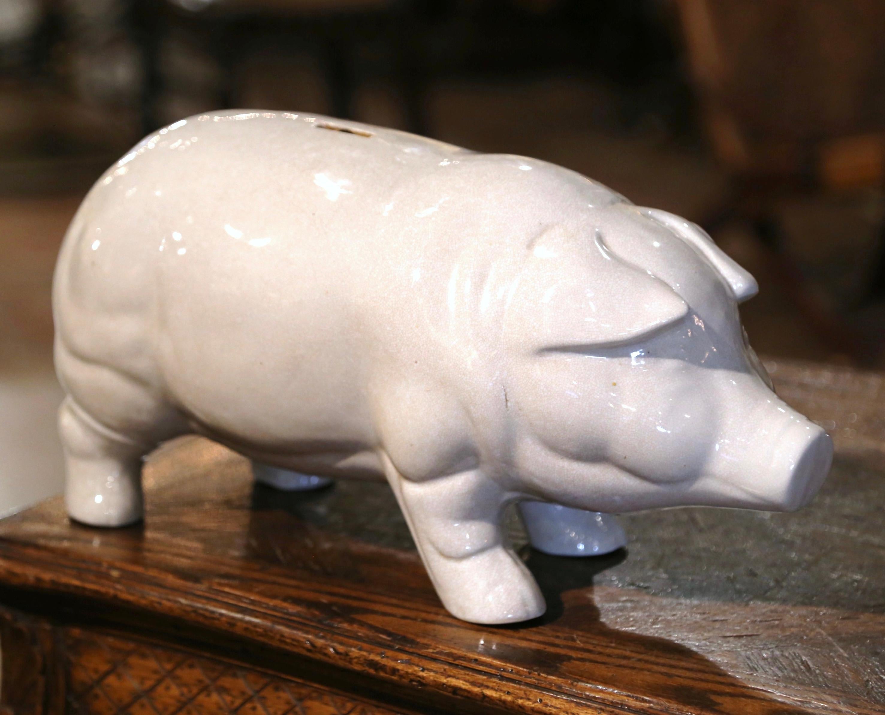 Decorate a kitchen island with this large ceramic pig sculpture. Crafted in northern France, circa 1970, the vintage faience farm animal figure in a standing position has a charming expression, a sweet face, and a crackled, rustic finish with a slot