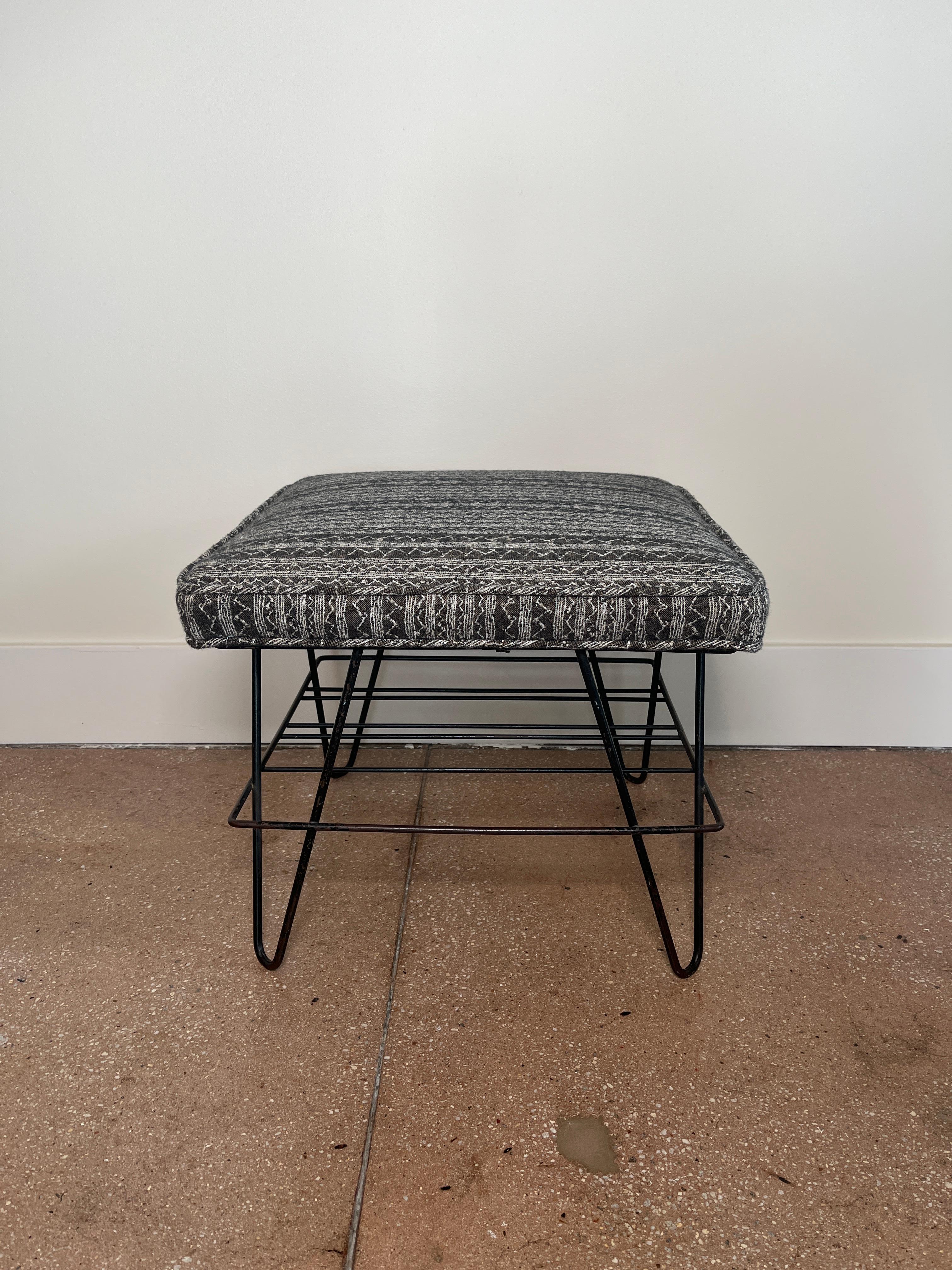 Midcentury French ottoman with iron hairpin legs and recently upholstered seat cushion with self-welting. Iron shelf at 6