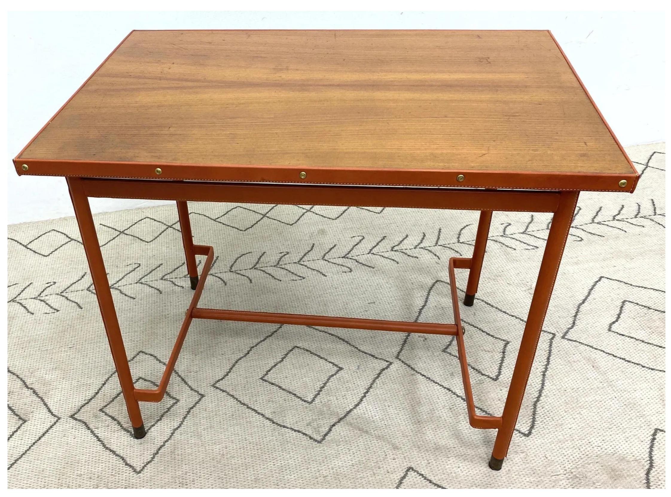 Midcentury French leather-wrapped writing table / desk attributed to Jacques Adnet (unmarked). Iron base and frame around the wood top are wrapped in cognac leather with contract stitching and brass fittings, in the iconic Adnet style. Very good