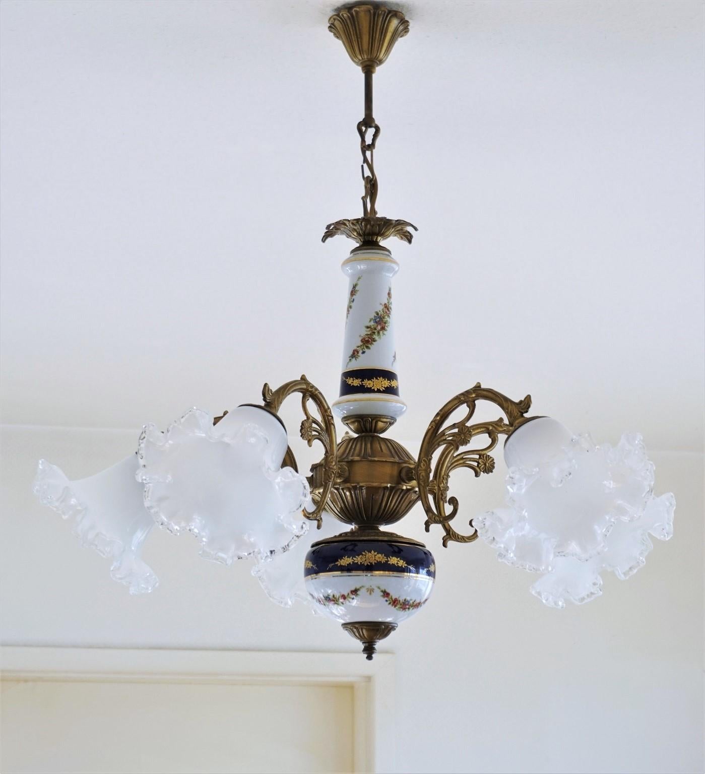 Vintage Limoges porcelain and burnished brass chandelier, five-arm with Murano glass shades, France, 1950s. White and cobalt blue hand painted porcelain with floral motifs and gilded decor.
Very good condition: Rewired, on porcelain and glass no