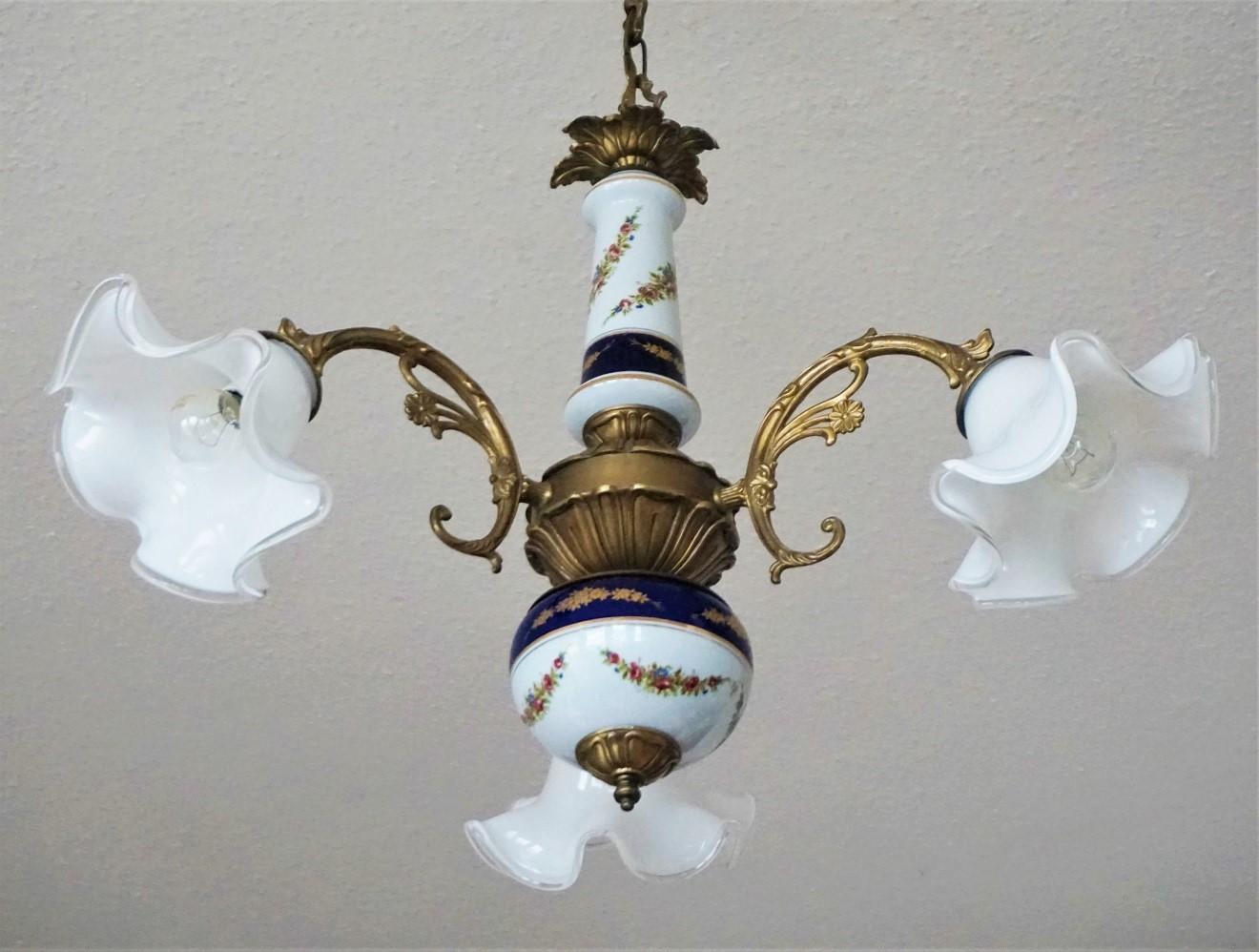 Vintage Limoges porcelain and burnished brass chandelier, three curved arm with large Murano glass shades, France, 1950s. White and cobalt blue hand painted porcelain with floral motifs and gilded decor.
Very good condition: Rewired, on porcelain