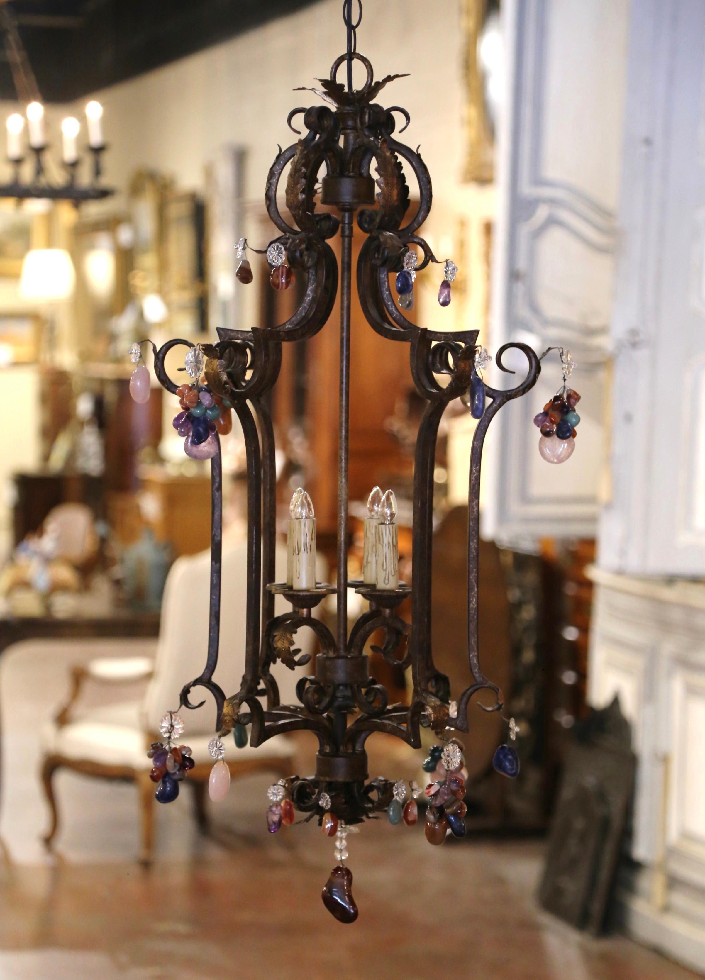 Crafted in France circa 1970, and square in shape, the lantern built of iron is decorated throughout with colorful crystal pendants, including bunch of grapes motifs. The tall lantern features a scrolled top, and is decorated with a pierced ornate