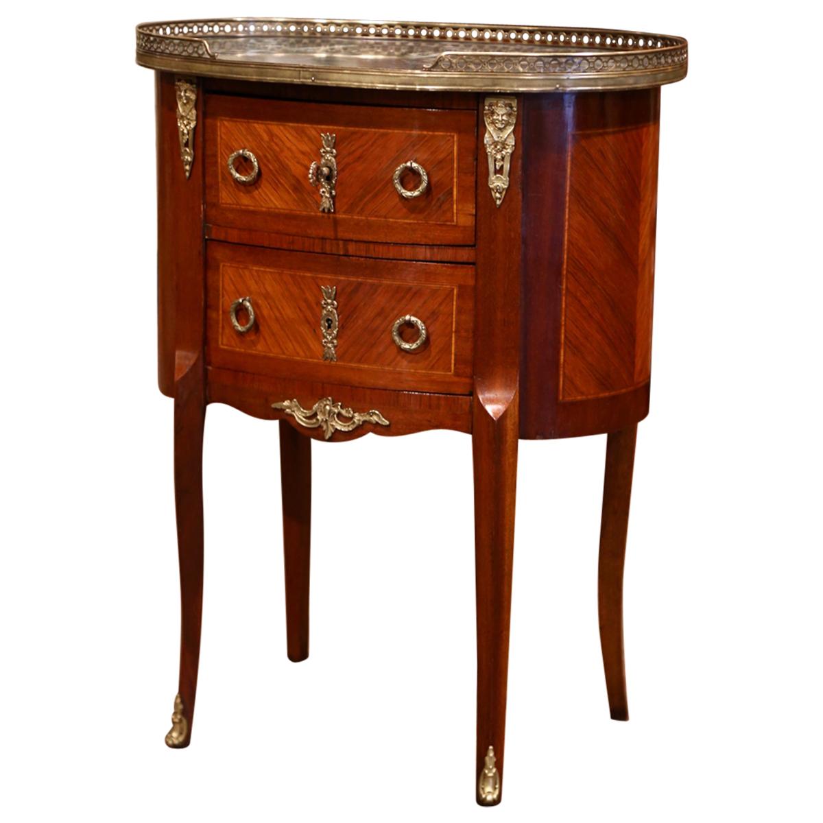 This elegant oval shape fruitwood antique commode was crafted in Paris, circa 1950. The chest sits on cabriole legs decorated with bronze sabot feet, over a scalloped apron embellished with a brass mount. The front has two drawers with marquetry