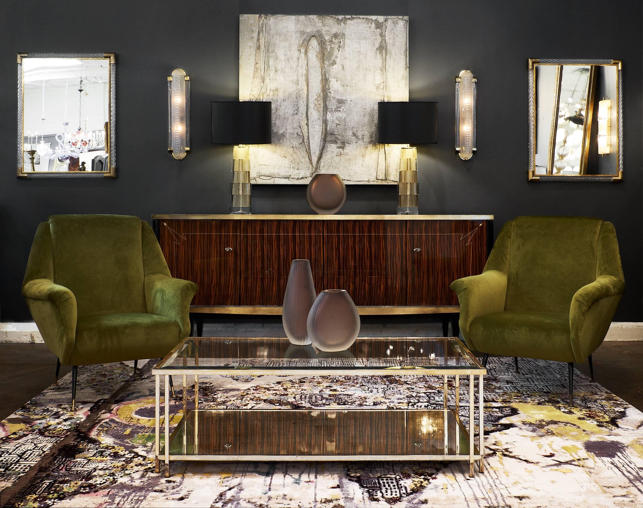 Spectacular French midcentury Macassar of ebony buffet or sideboard featuring four doors with working and original locks and keys. The legs are capped with gilt brass, and the top of the buffet has cobalt black glass. It is trimmed with brass. We