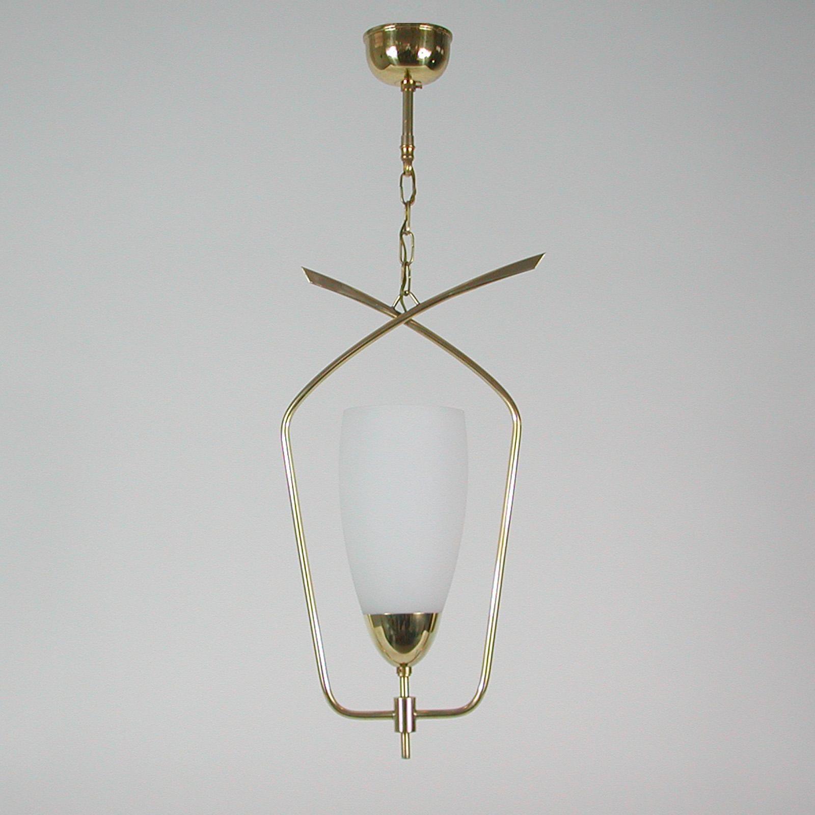 This elegant modernist suspension light or lantern was designed and manufactured in France in the late 1950s. It features a tulip shaped white opaline glass diffuser and brass hardware. 

All our lights are checked, cleaned and suitable for use in