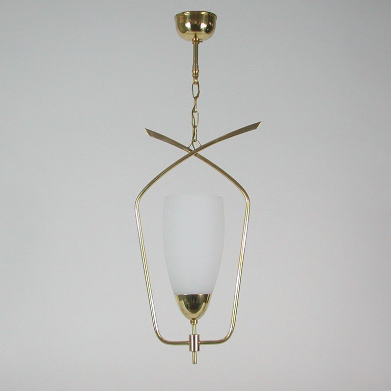 This elegant modernist suspension light or lantern was designed and manufactured in France in the late 1950s. It features a tulip shaped white opaline glass diffuser and brass hardware. 

All our lights are checked, cleaned and suitable for use in