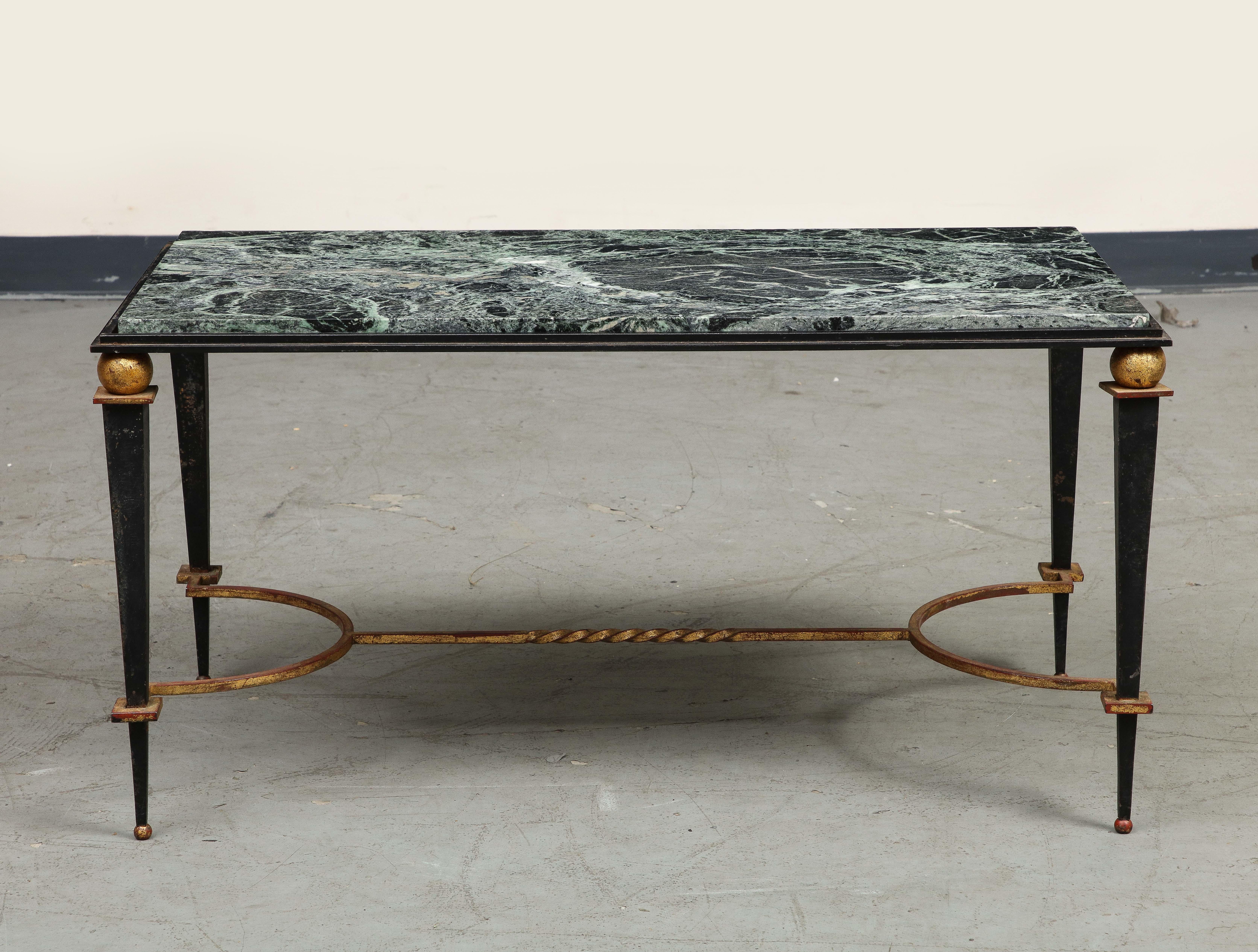 Neoclassical style midcentury French iron coffee table, in the style of Maison Jansen. Attractive black and dark green marble top sits on tapered iron legs with gilt details and a gilt stretcher.
