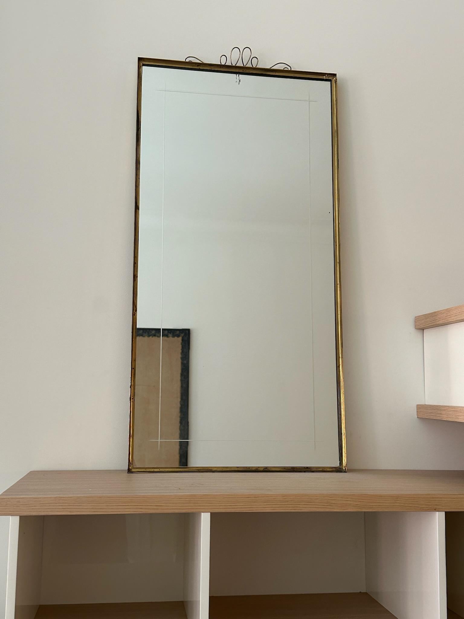 Magnifique long miroir en laiton avec un cadre fin et des détails en fil de fer, circa 1960 France. 