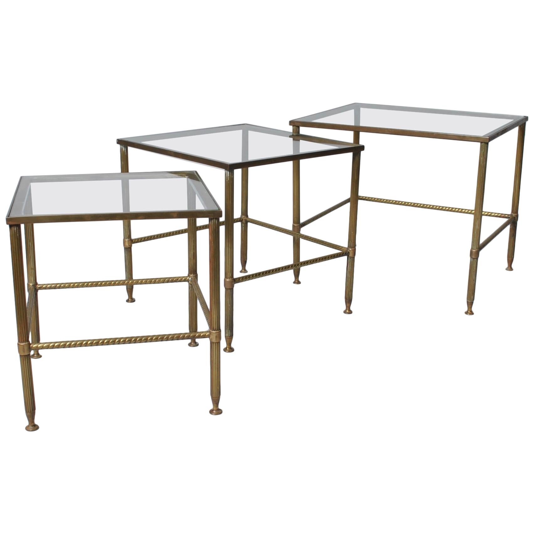 A set of very fine quality midcentury French Maison nesting tables. Produced in France, circa 1950. Superb aged patination to the brass roped and fluted frames. Classic, stylish and practical pieces.
         