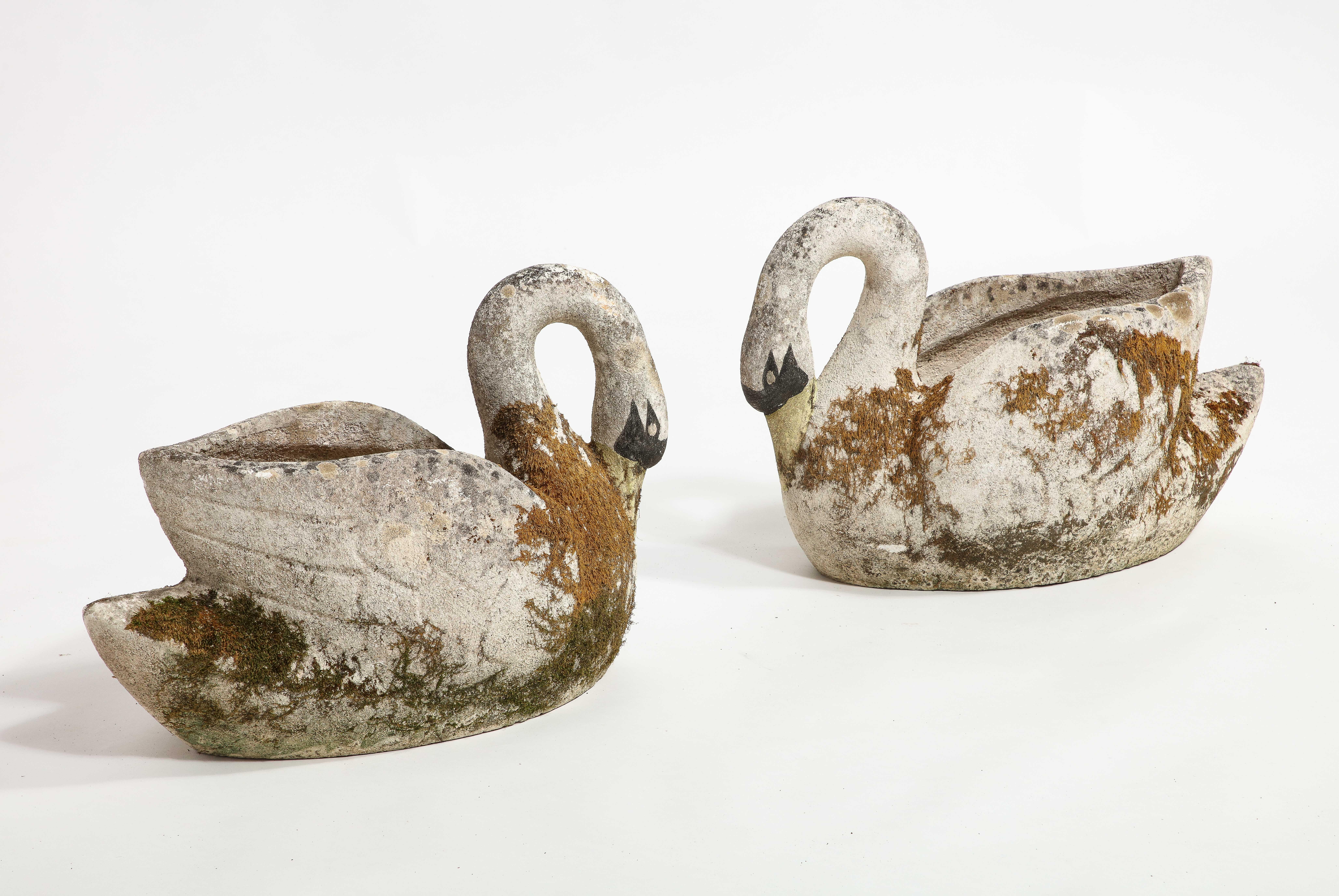 Midcentury French pair of exquisite concrete swan planters or jardinières with curvaceous forms including elegant long curved necks and painted faces and beaks. These lovely vintage swan planters were cast in cement and have beautifully aged through