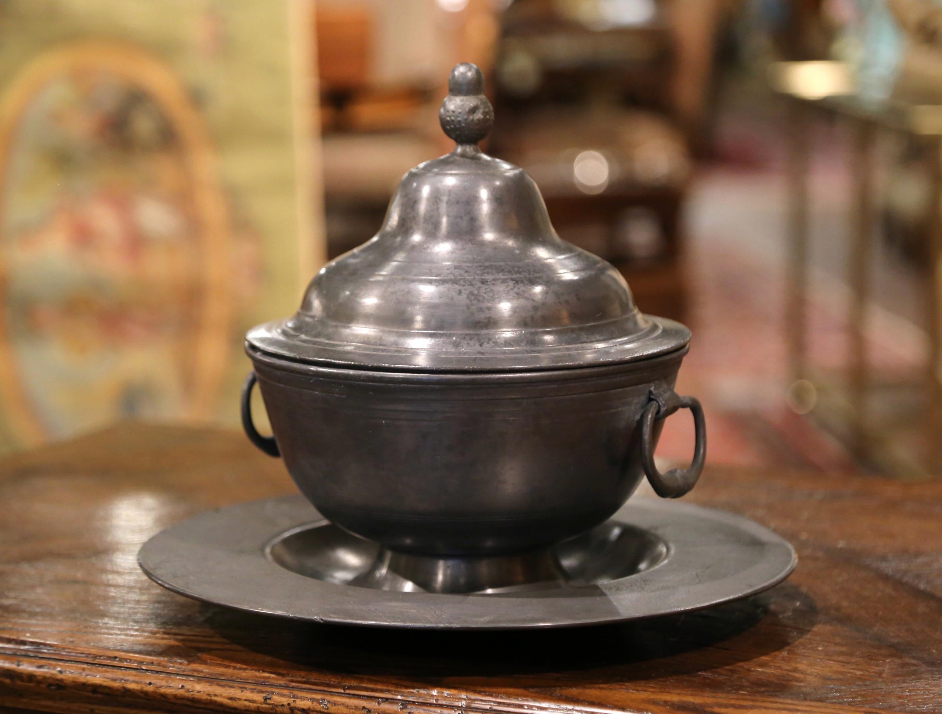 Decorate a dining room table with this elegant vintage centerpiece; crafted in France circa 1950, the pewter composition features a round tureen with handle and lid decorated with finial and the matching tray. The three-piece centerpiece is in