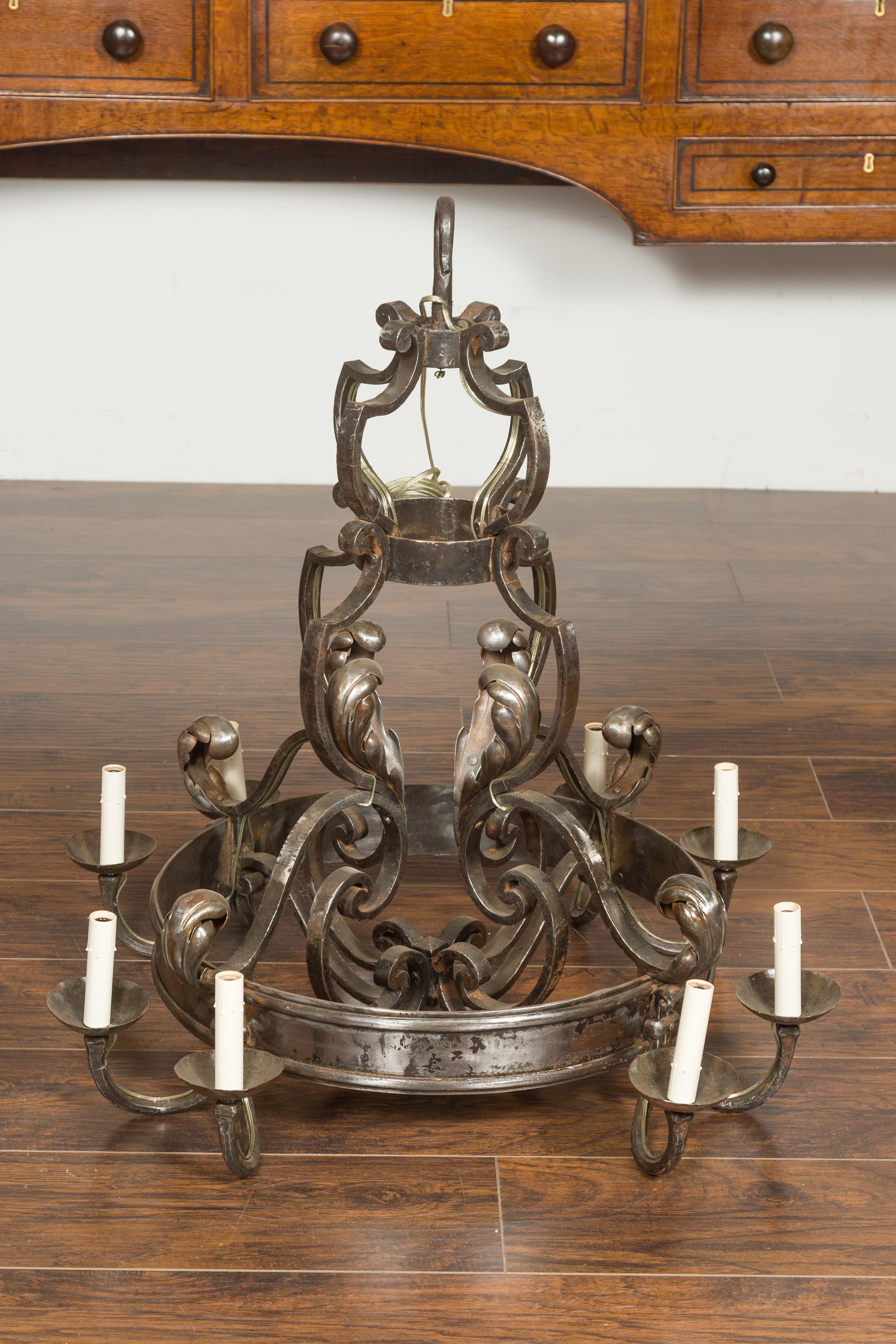 A French vintage polished steel eight-light chandelier from the mid-20th century, with acanthus leaves, rings and scrolling arms. Crafted in France during the midcentury period, this polished steel chandelier features an harmonious arrangement of