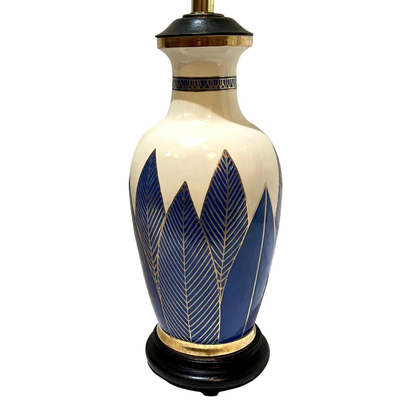 A circa 1950's French what and blue porcelain table lamps with gilt details.

Measurements:
Height of body: 16”
Diameter: 6”.