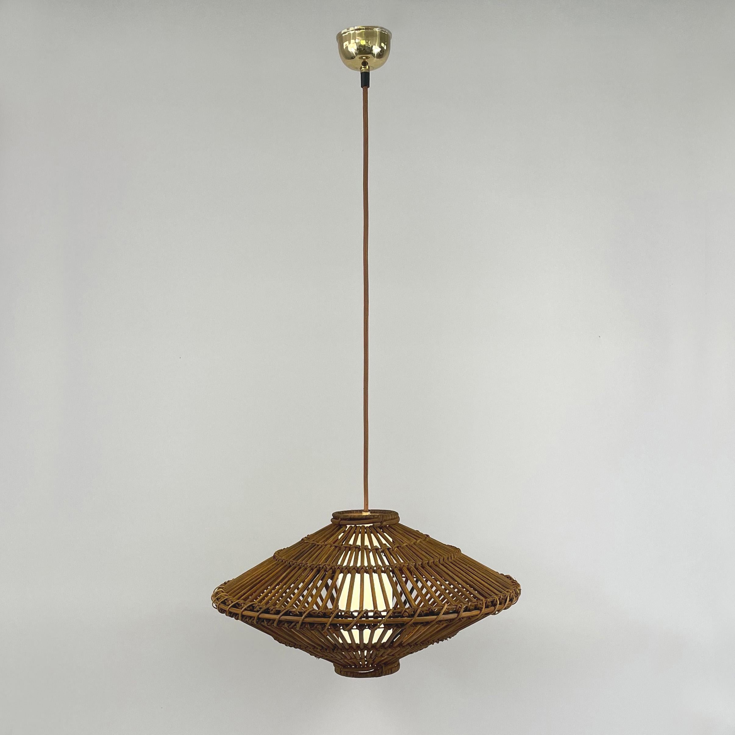 This beautiful handcrafted Louis Sognot style pendant was designed and manufactured in France in the 1960s. It features a large rattan lampshade, light brown silk cord and an off-white linen covered diffuser. Brass canopy.

The light has been