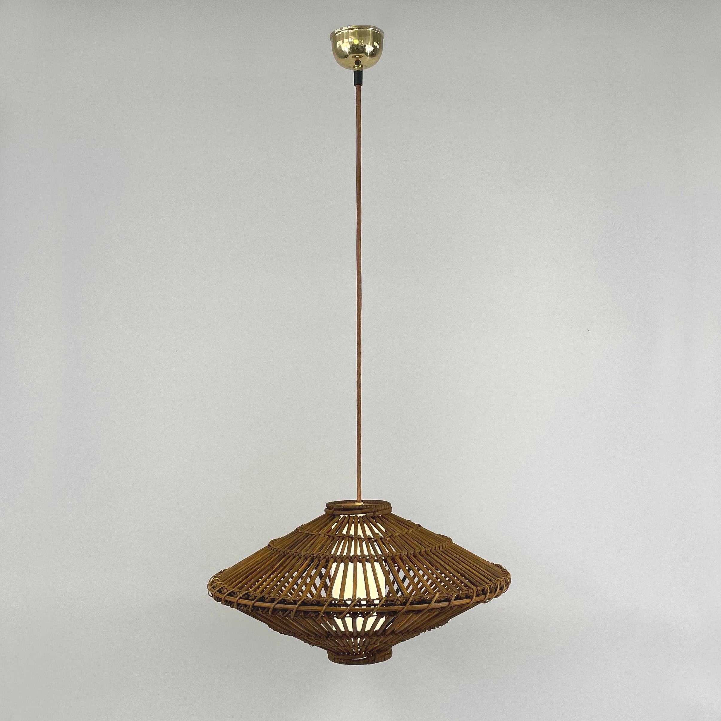 This beautiful handcrafted Louis Sognot style pendant was designed and manufactured in France in the 1960s. It features a large rattan lampshade, light brown silk cord and an off-white linen covered diffuser. Brass canopy.

The light has been