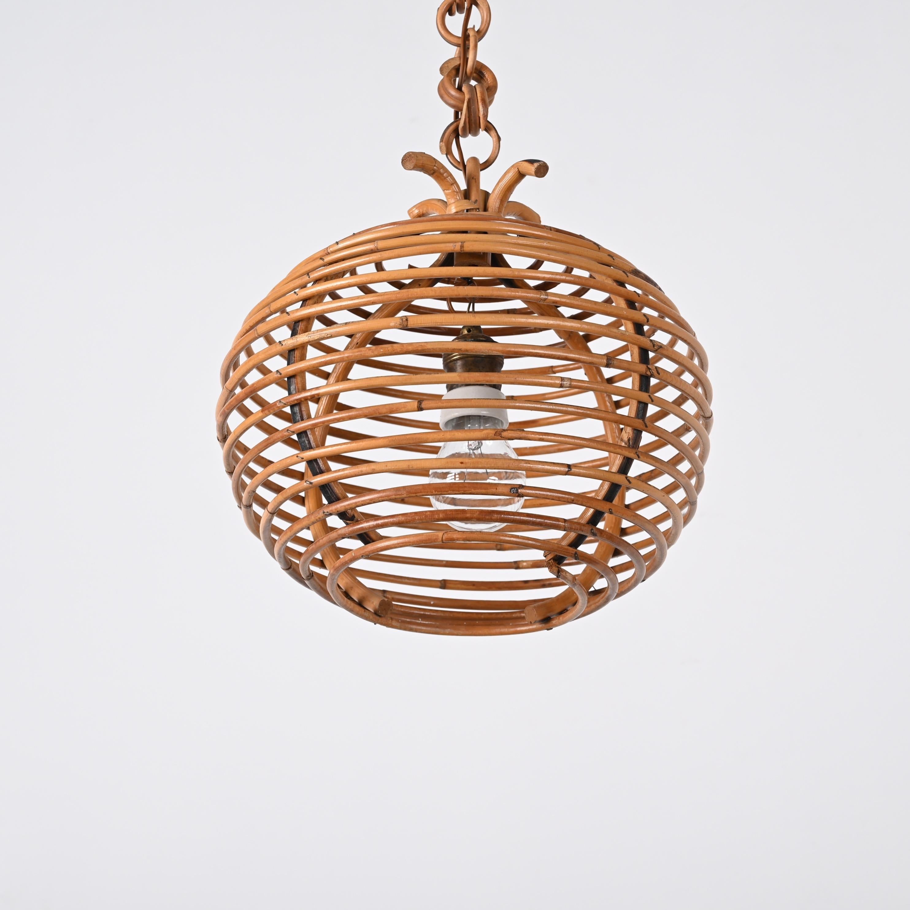Stunning midcentury bamboo and rattan spherical chandelier in Cote d'Azur style. This wonderful item was produced in Italy during the 1960s.

This gorgeous pendant features a spherical shape made by a spiral of curved rattan and an elegant rattan