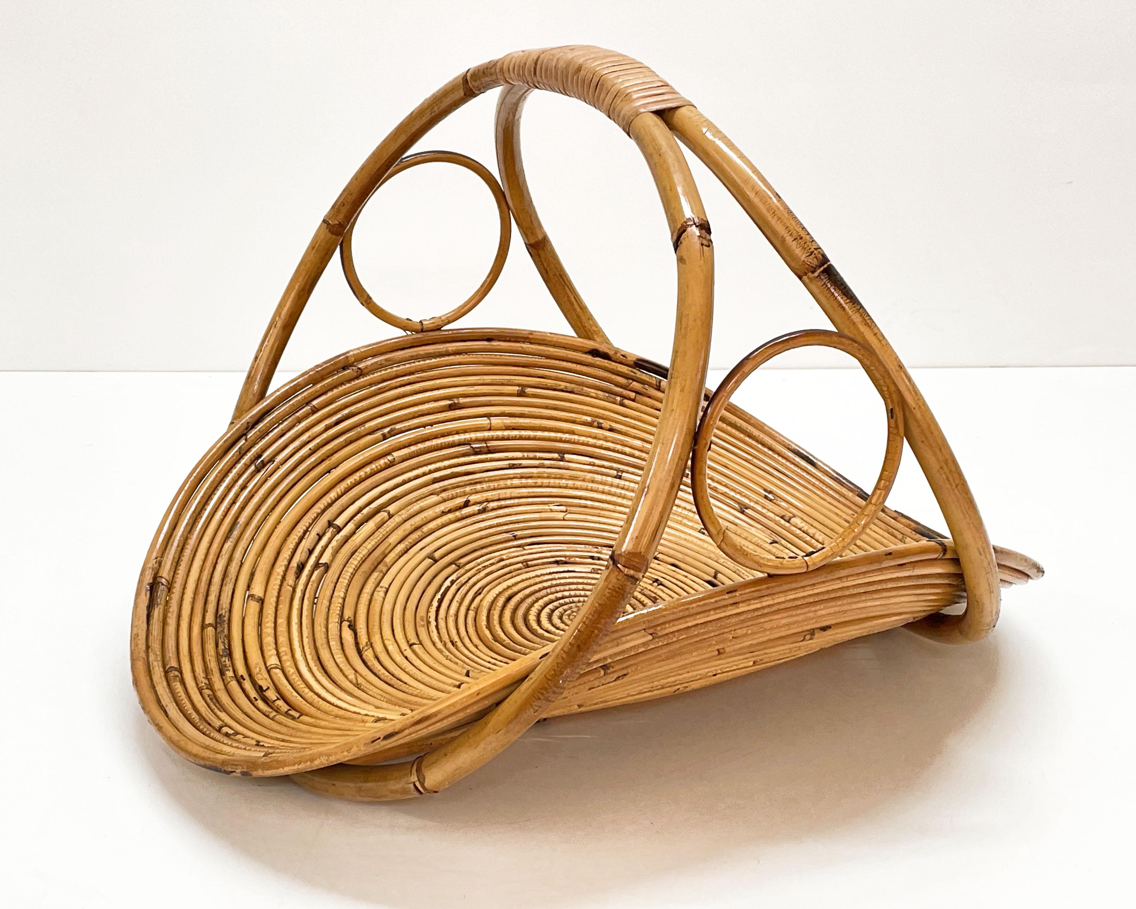 Midcentury French Riviera bamboo and rattan magazine rack. This item was produced in Italy during the 1960s.

This wonderful piece is very rare as it is in perfect balance, standing perfectly even if just the central part is on the ground. On the