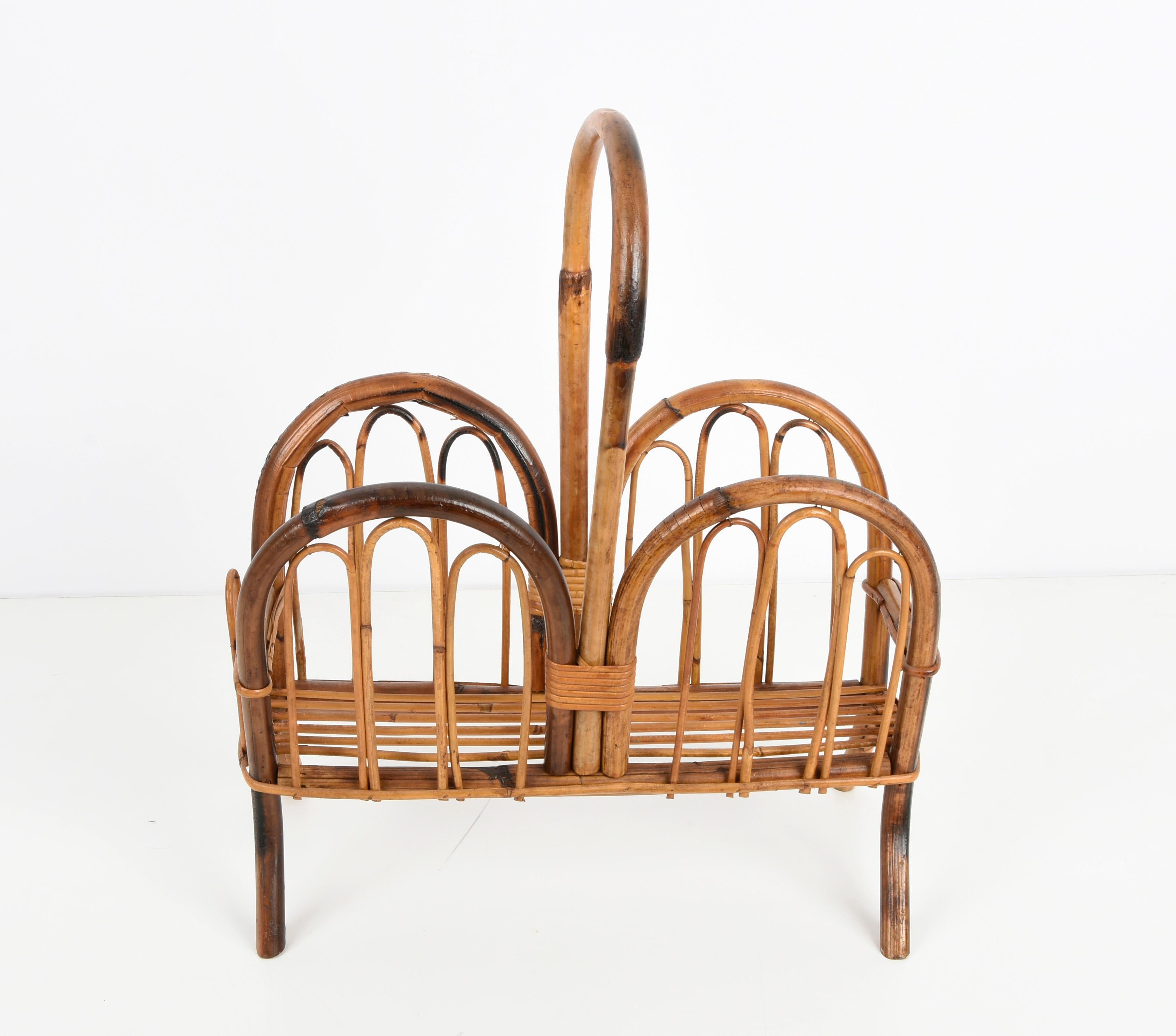 Amazing midcentury French riviera magazine rack in bamboo and rattan. This wonderful piece was produced in Italy during the 1960s.

This magazine rack is unique as the bamboo structure has a curved shape ending with elegant feet.

A great item