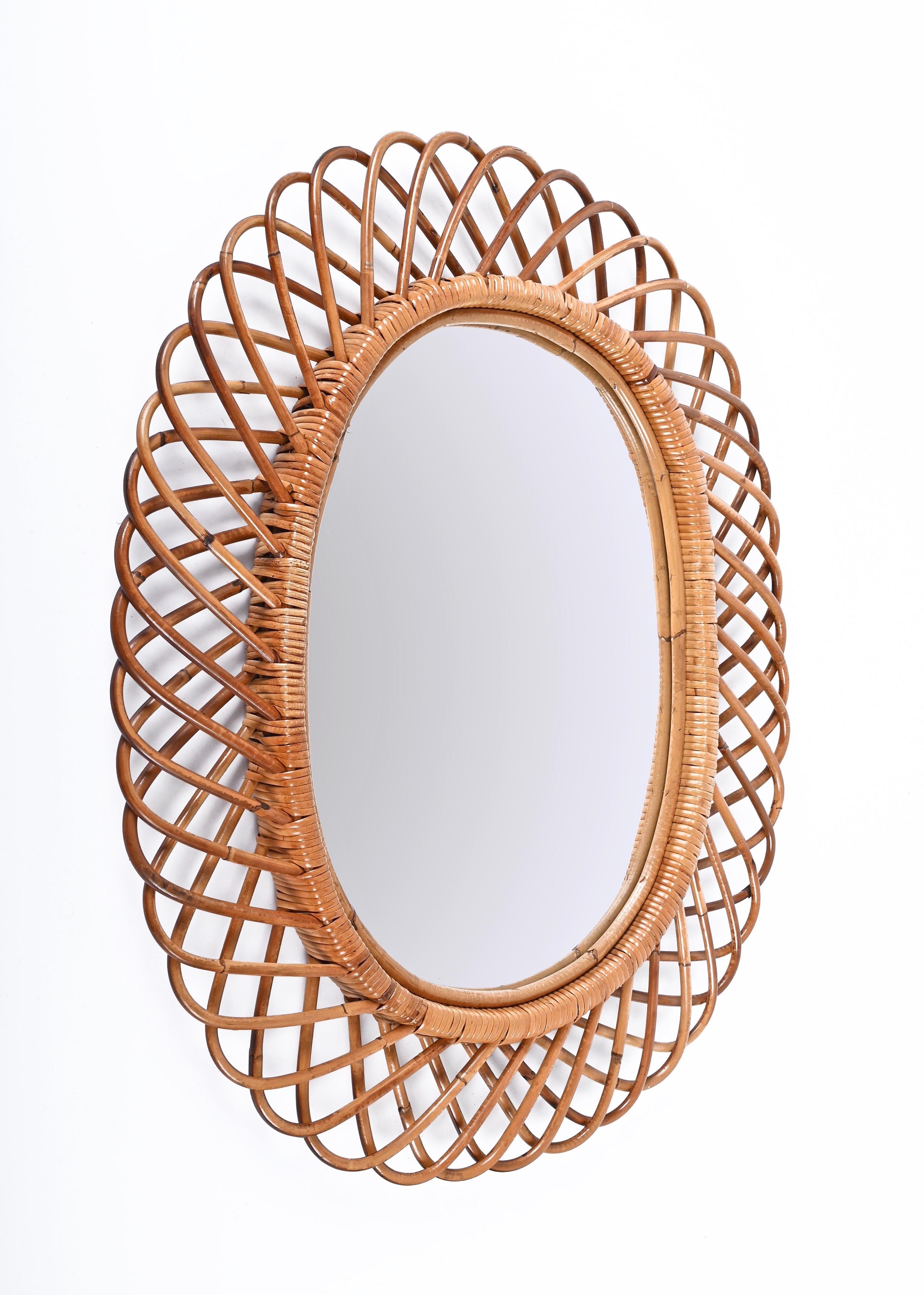 Amazing huge midcentury French Riviera rattan and bamboo oval mirror. This marvellous object is attributed to Franco Albini as designer and Bonacina and was produced in Italy during the 1960s.

This decorative oval mirror is unique as it has a