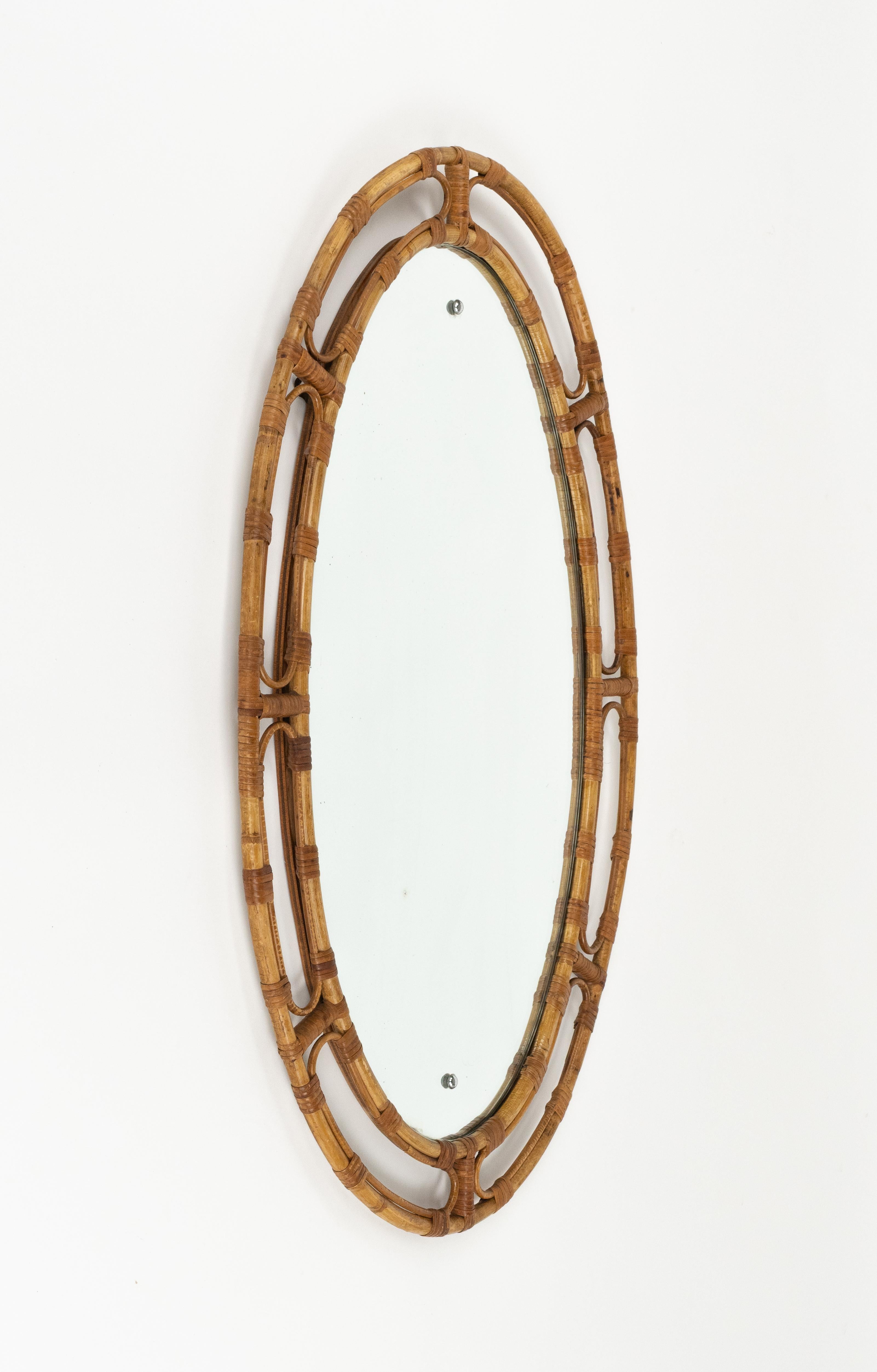 Specchio ovale da parete in rattan e bambù nello stile di Franco Albini.

Prodotto in Italia negli anni '1960.

La cornice presenta una raffinata lavorazione ad intreccio, con elementi curvi e sezioni ad arco che richiamano l'estetica del design