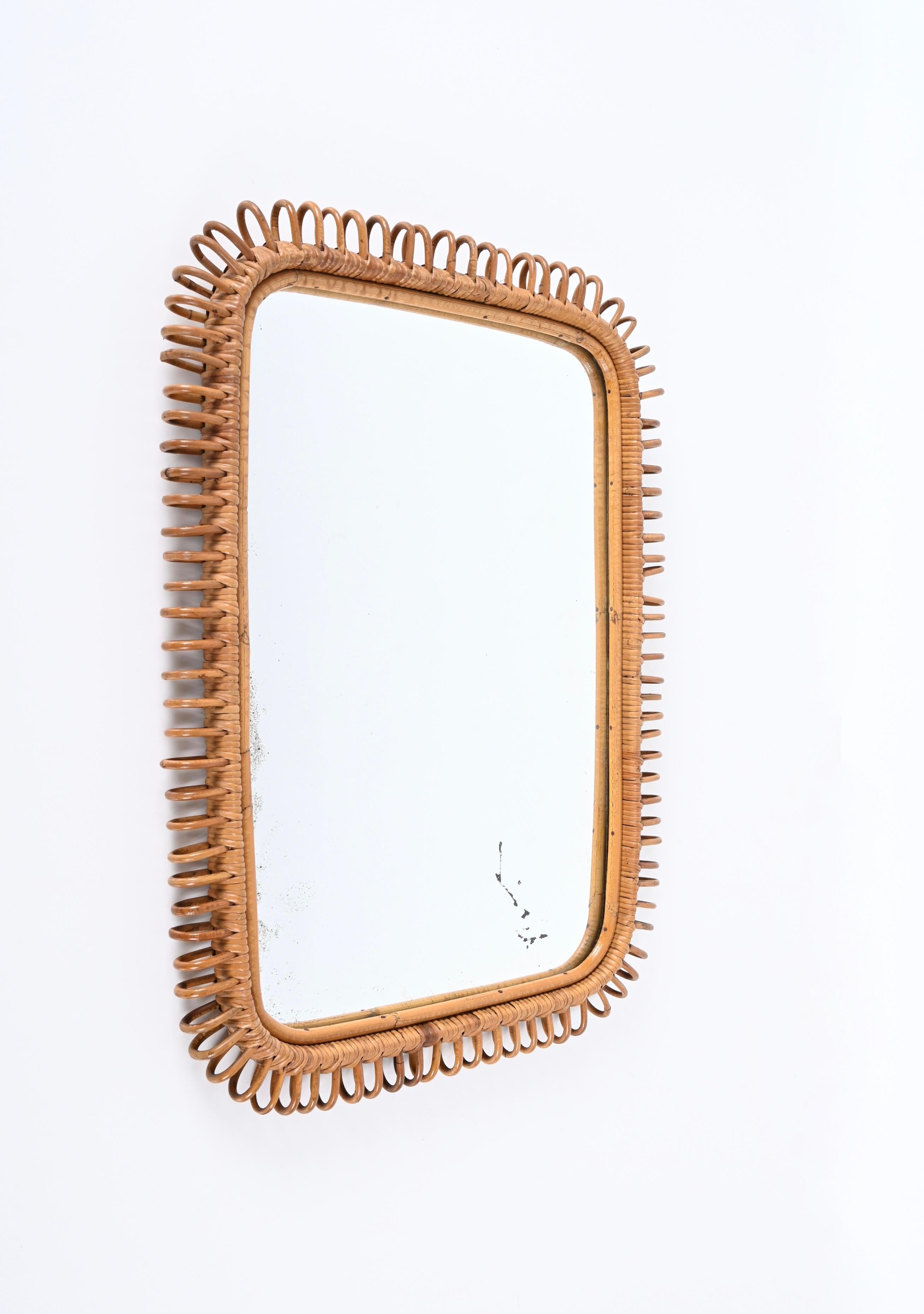 Fantastic large rectangular wall mirror in bamboo and rattan. This Cote d'Azur style mirror is attributed to the craftsmanship of Franco Albini and was designed in Italy during the 1970s.

The glass mirror is original and signed on the back with the
