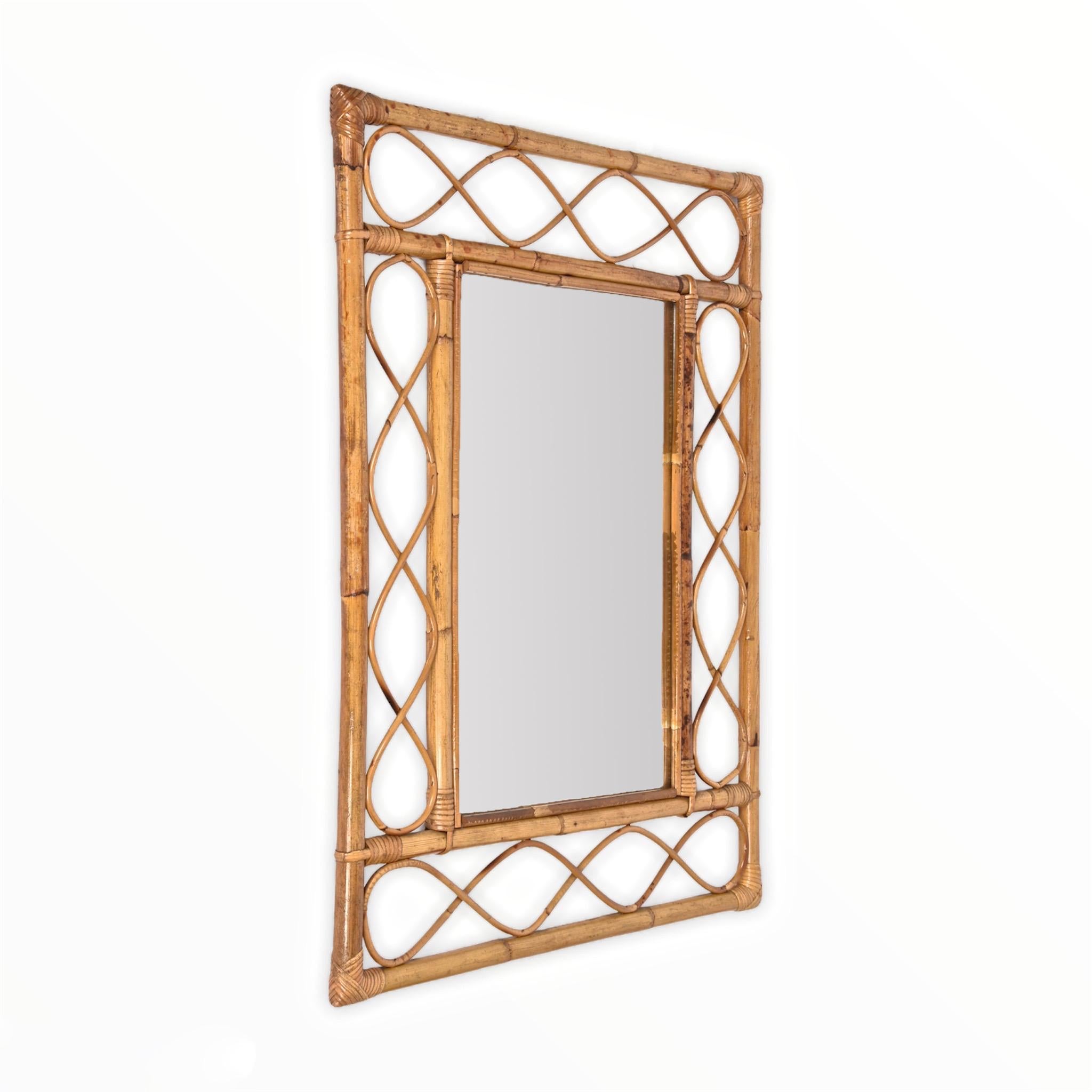Marvellous midcentury French riviera wall mirror in bamboo and rattan. This item was produced in France in the mid-1960s.

The mirror its original and good vintage conditions, and the use of the materials and the lines, the straight bamboo and