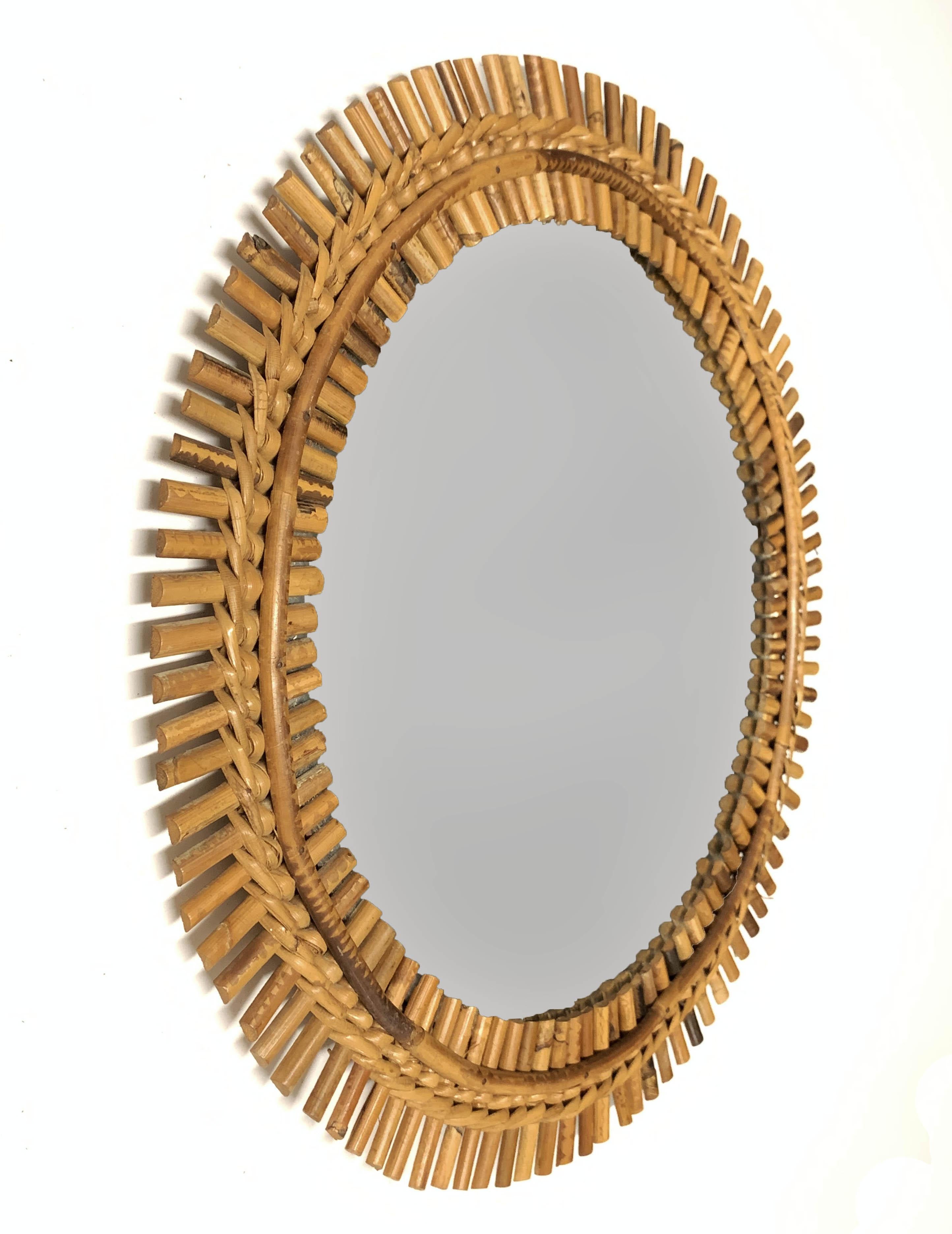 Cote d'Azur round wall mirror with a bamboo and rattan frame, produced in France during 1960s.

This amazing mirror is in its original, good conditions. It has the unmistakable design of the 1960s and will, with its elegance, remind the breeze of